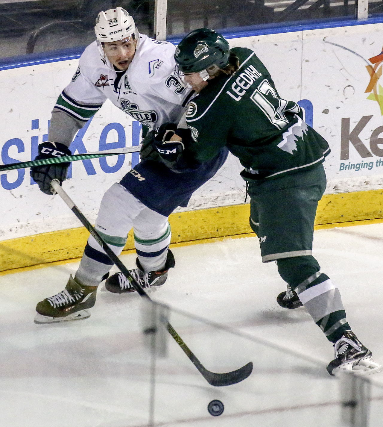 THe Thunderbirds’ Jared Hauf controls the puck with the Silvertips’ Dawson Leedahl crashing in during a playoff game Friday night at the ShoWare Center in Kent.