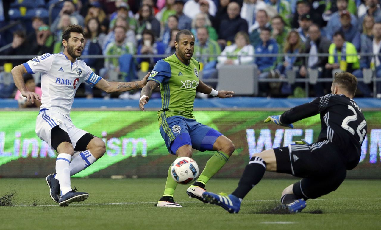 Sounders goalkeeper Stefan Frei stops a shot by Montreal’s Ignacio Piatti as Seattle defender Tyrone Mears looks on during the first half of Saturday’s game.