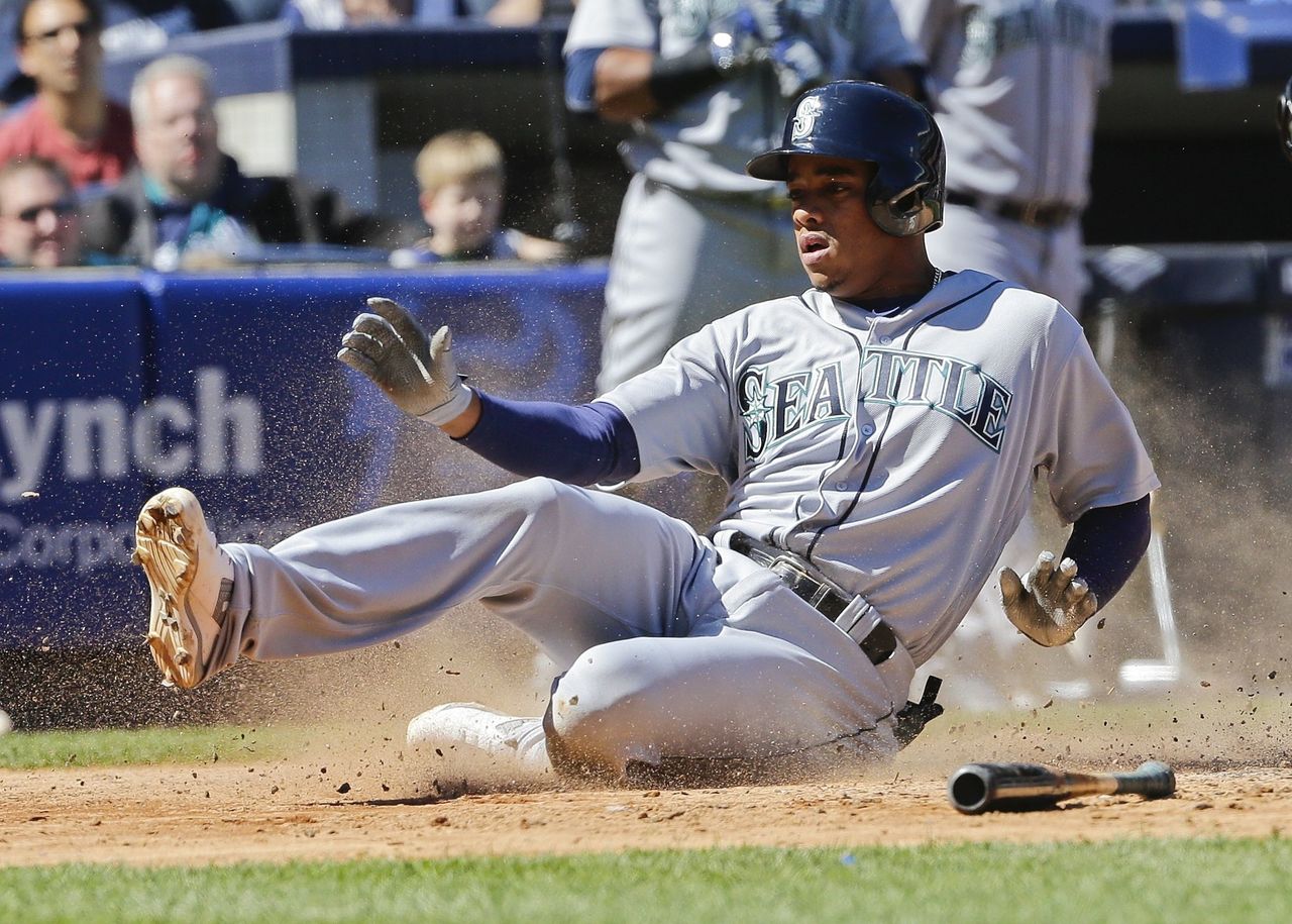 The Mariners’ Ketel Marte slides across the plate, scoring from first base on a two-out single by Robinson Cano during the fifth inning of Saturday’s game against the Yankees.