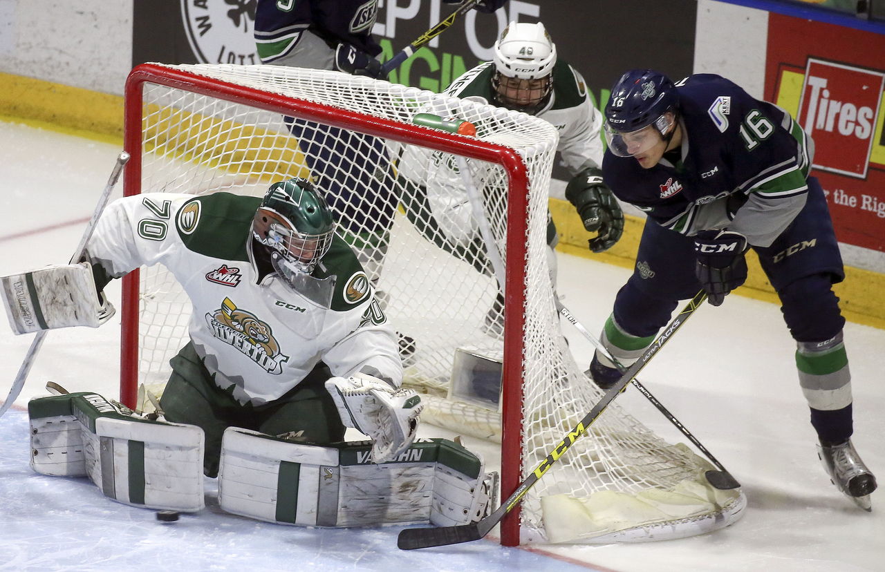 The Thunderbirds’ Alexander True attempts a shot at goal against the Silvertips’ Carter Hart with Everett’s Gino Fairbrother trailing Friday in Everett.