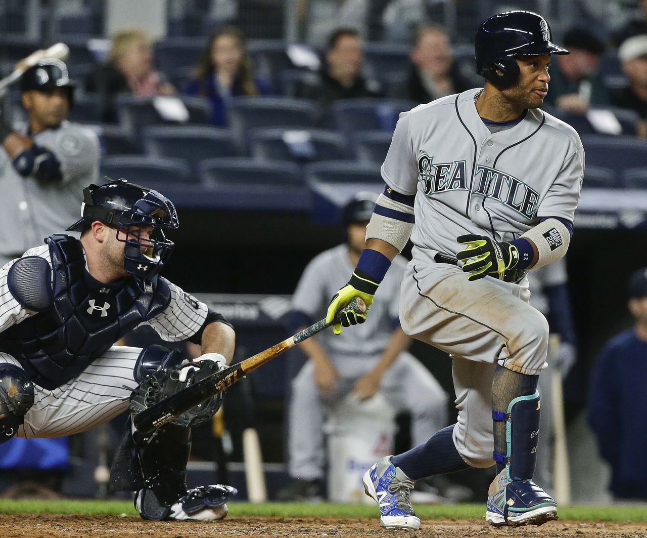 The Mariners Robinson Cano follows through on an RBI single as Yankees catcher Brian McCann watches during a game Friday in New York.