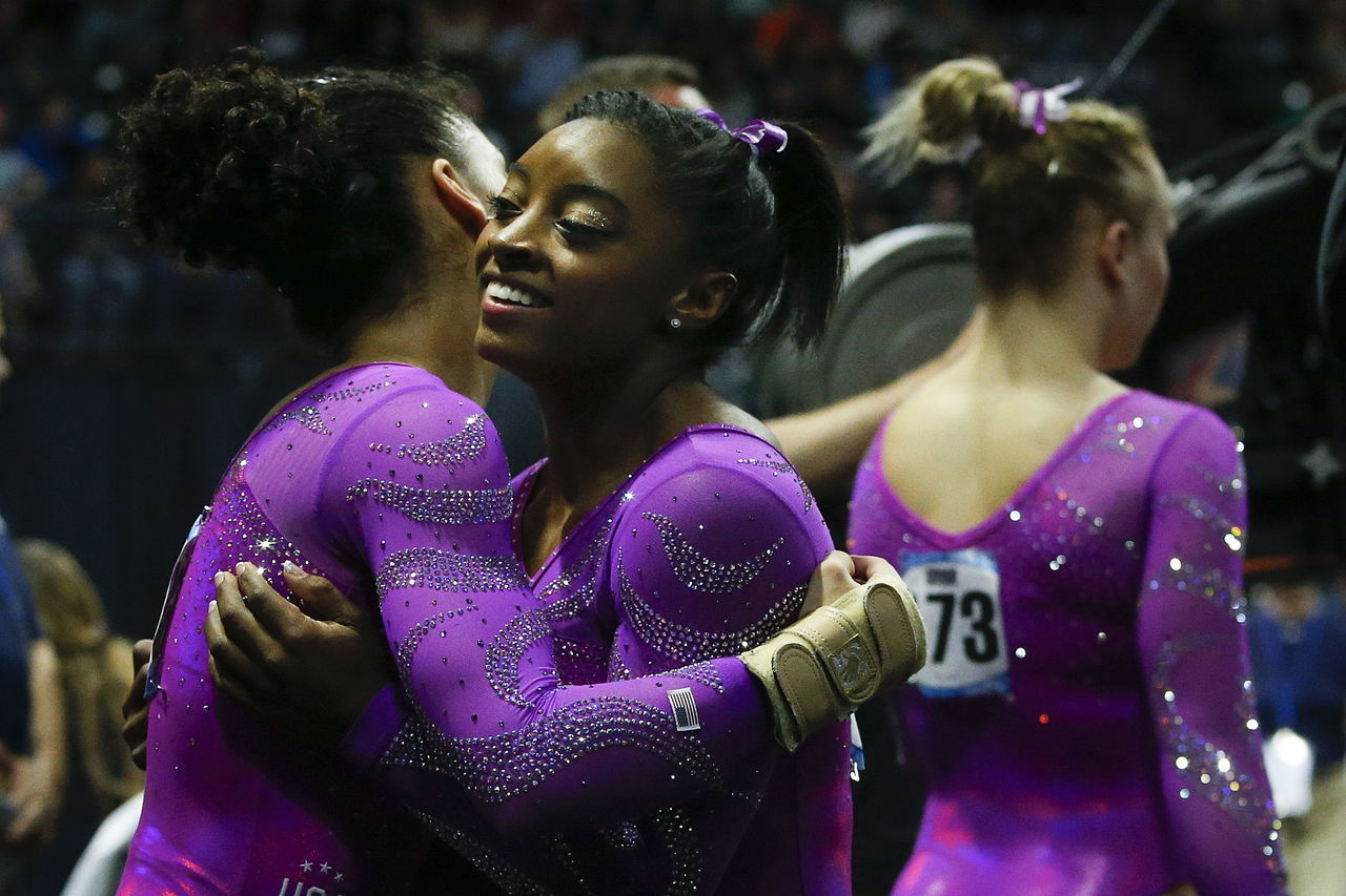 The United State’s Simone Biles (center) is congratulated by teammates during the second day of competition at the Pacific Rim Championships on Saturday at Xfinity Arena in Everett.