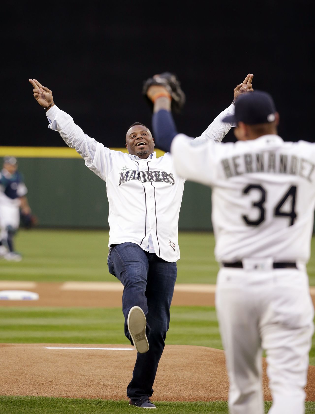 Mariner great Ken Griffey Jr. playfully mimics the motion made by pitcher Felix Hernandez (34) from a no-hitter years earlier after Griffey threw out the ceremonial first pitch before the Mariners’ home-opener against the Athletics on Friday in Seattle.