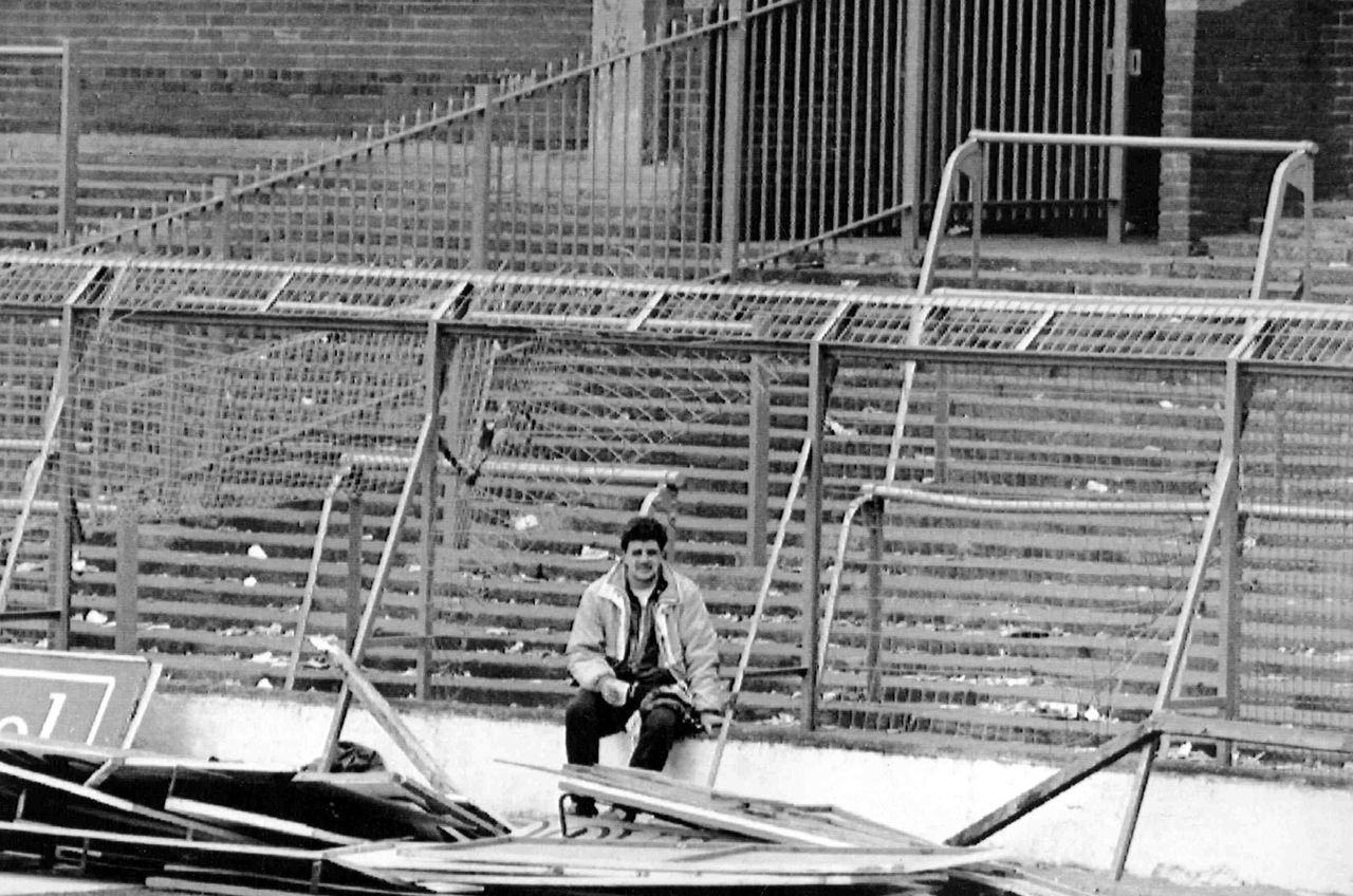 In This April 15, 1989, photo, a lone soccer supporter sits by the damaged fencing at Hillsborough Stadium, in Sheffield, England.