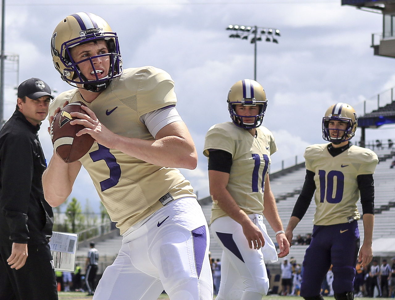 Jake Browning (3) drops back to pass during a drill with K.J. Carta-Samuels (center) and Tony Rodriguez looking on at Husky Football Spring Preview and Fan Fest on Saturday afternoon at Husky Stadium in Seattle.
