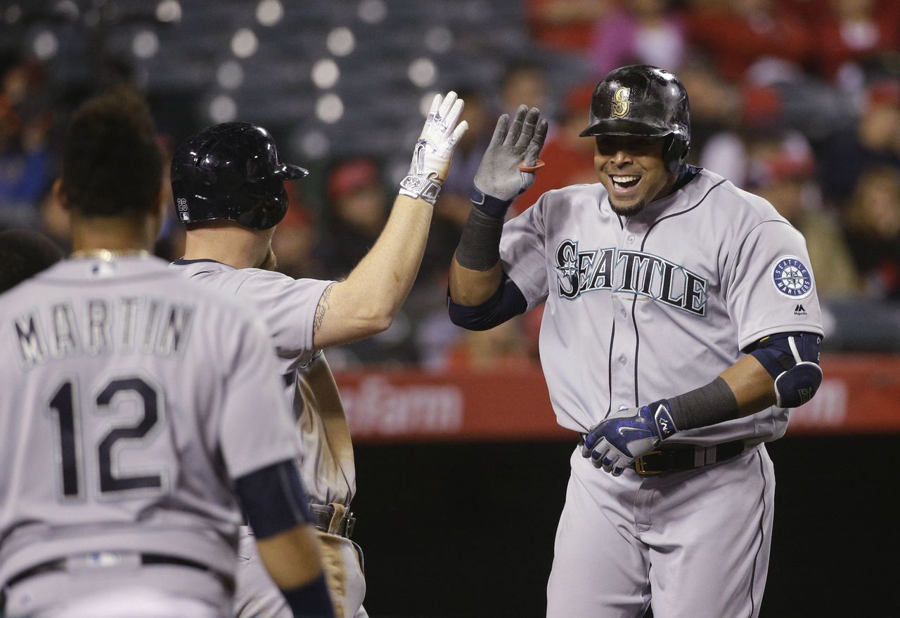 The Mariners’ Nelson Cruz (right) celebrates his two-run home run with Adam Lind during the 10th inning of a game against the Los Angeles Angels on Friday in Anaheim, Calif.