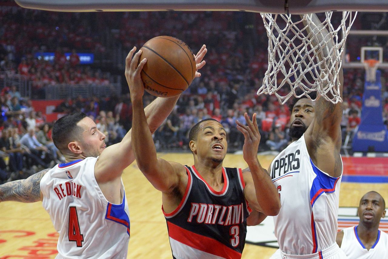 Portland Trail Blazers guard C.J. McCollum (center) shoots as Los Angeles Clippers guard J.J. Redick (left) and center DeAndre Jordan defend during the first half of Game 2 of their first-round NBA playoff series.