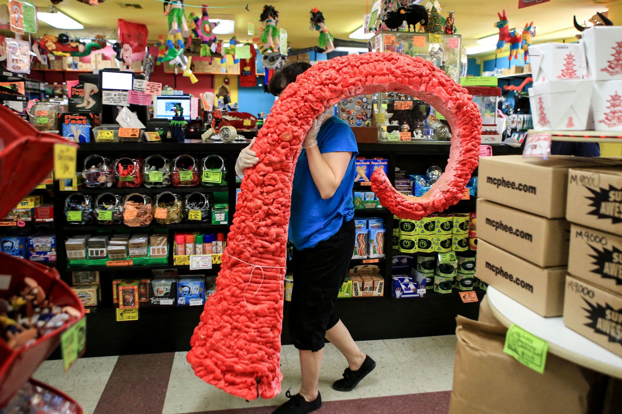 Jackie Sugita carries a phased-out display piece to the garbage last month at Archie McPhee in the Wallingford neighborhood of Seattle. (Kevin Clark / The Herald)