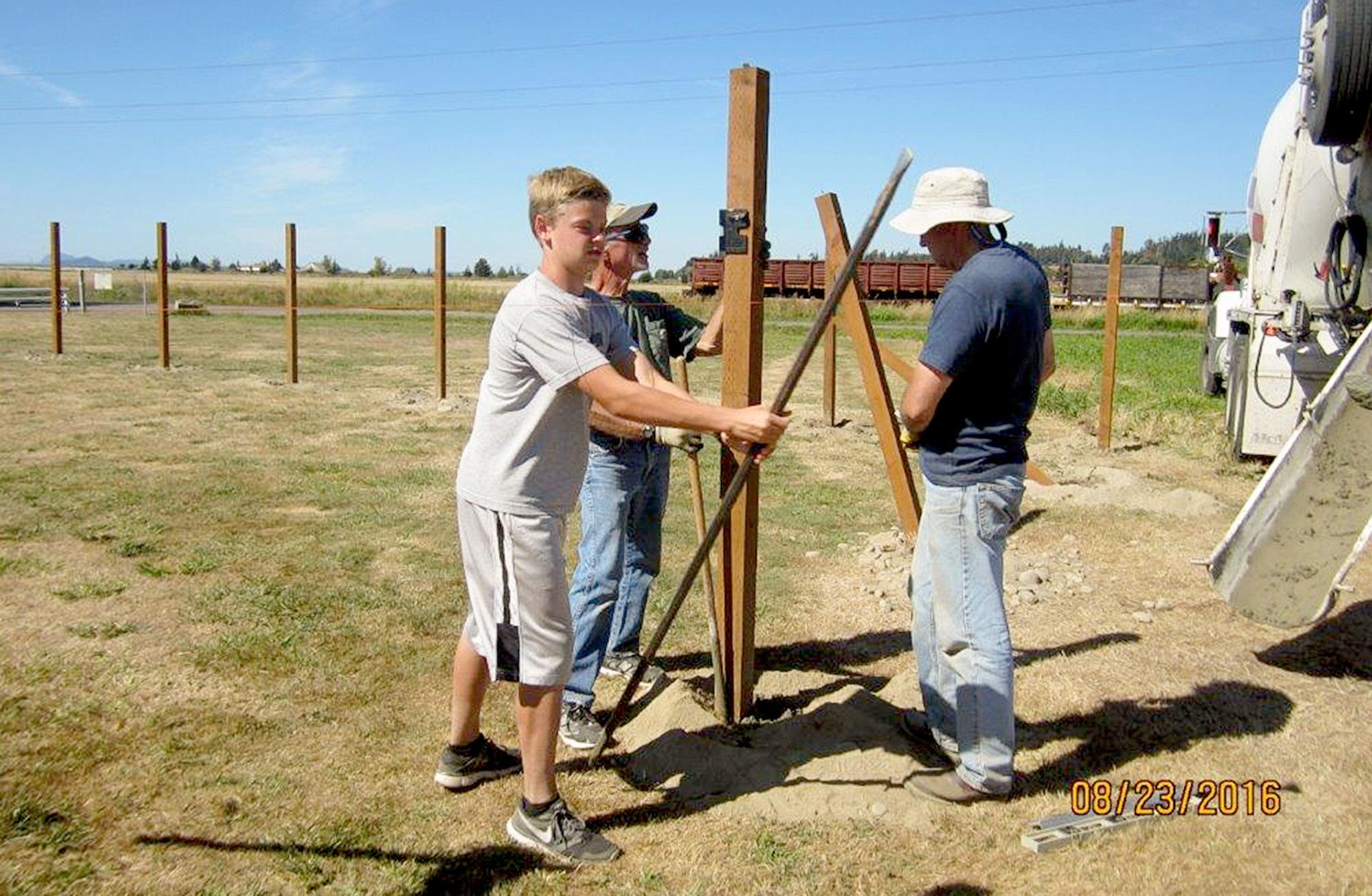 Landon McInelly holds a steel breaker bar as Chris McInelly, Landon’s dad (right) and Jim Zakopyko install posts for a dog park in Stanwood. Landon, 14, chose to build a dog area at Heritage Park, 9600 276th St., for his Eagle Scout Project. (Photo Courtesy The McInelly Family)