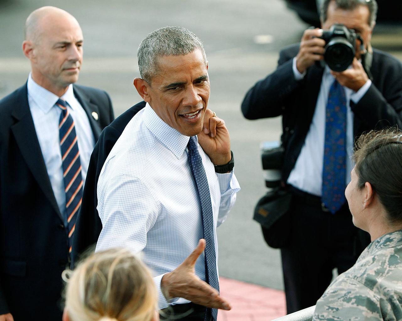 U.S. President Barack Obama greets military personnel after he arrives on Air Force One at Joint Base Pearl Harbor-Hickam on Wednesday in Honolulu. (AP Photo/Marco Garcia)