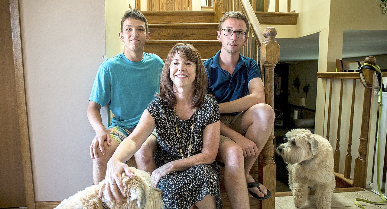 Sharon Tassone, who started a summer camp for kids with fetal alcohol spectrum disorder, poses with sons Nicholas, 21, right, and Alexander, 17, with dogs Finn and Izzy at their home in Tinley Park, Illinois. (Zbigniew Bzdak/Chicago Tribune)