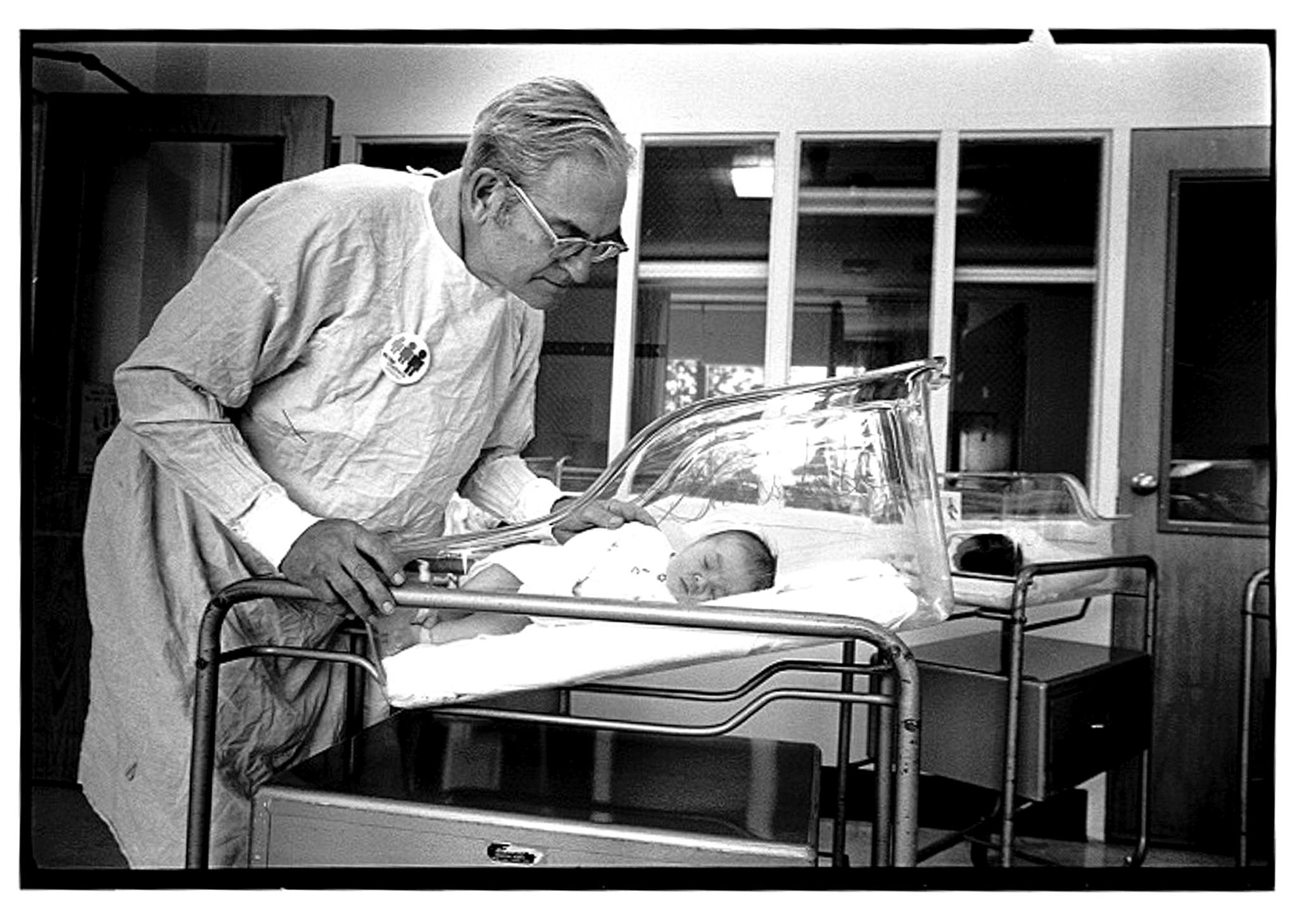 Dr. Robert Guthrie, the “Father of Newborn Screening” checks on an infant who benefitted from his work in this 1982 photo. (Courtesy of University Archives, State University of New York at Buffalo)