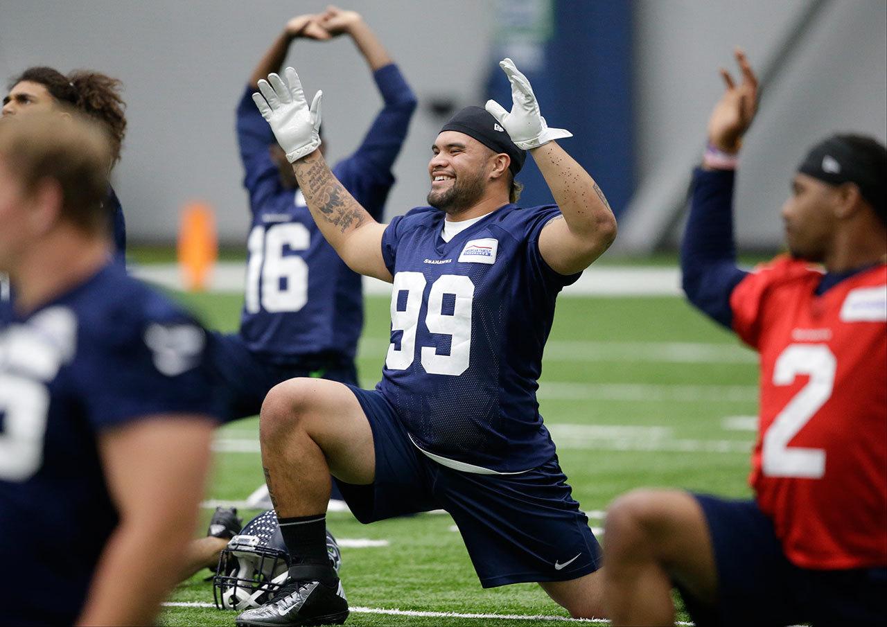 The Seahawks’ Taniela Tupou, an Archbishop Murphy alum, stretches during a rookie minicamp workout May 8 in Renton. (AP Photo/Elaine Thompson)