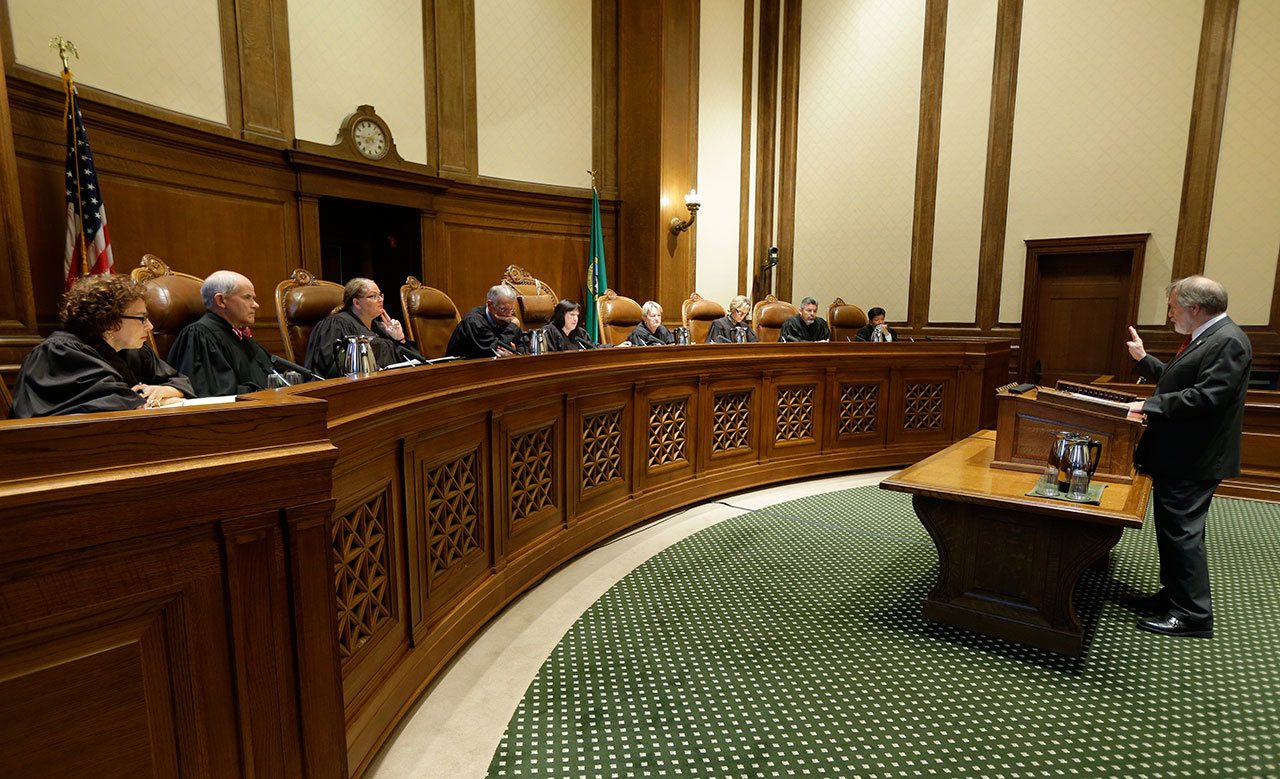 Alan Copsey (right), a deputy attorney general for the state of Washington, speaks during a hearing before the Washington State Supreme Court regarding a lawsuit against the state over education funding, Wednesday in Olympia. (Associated Press / Ted S. Warren)