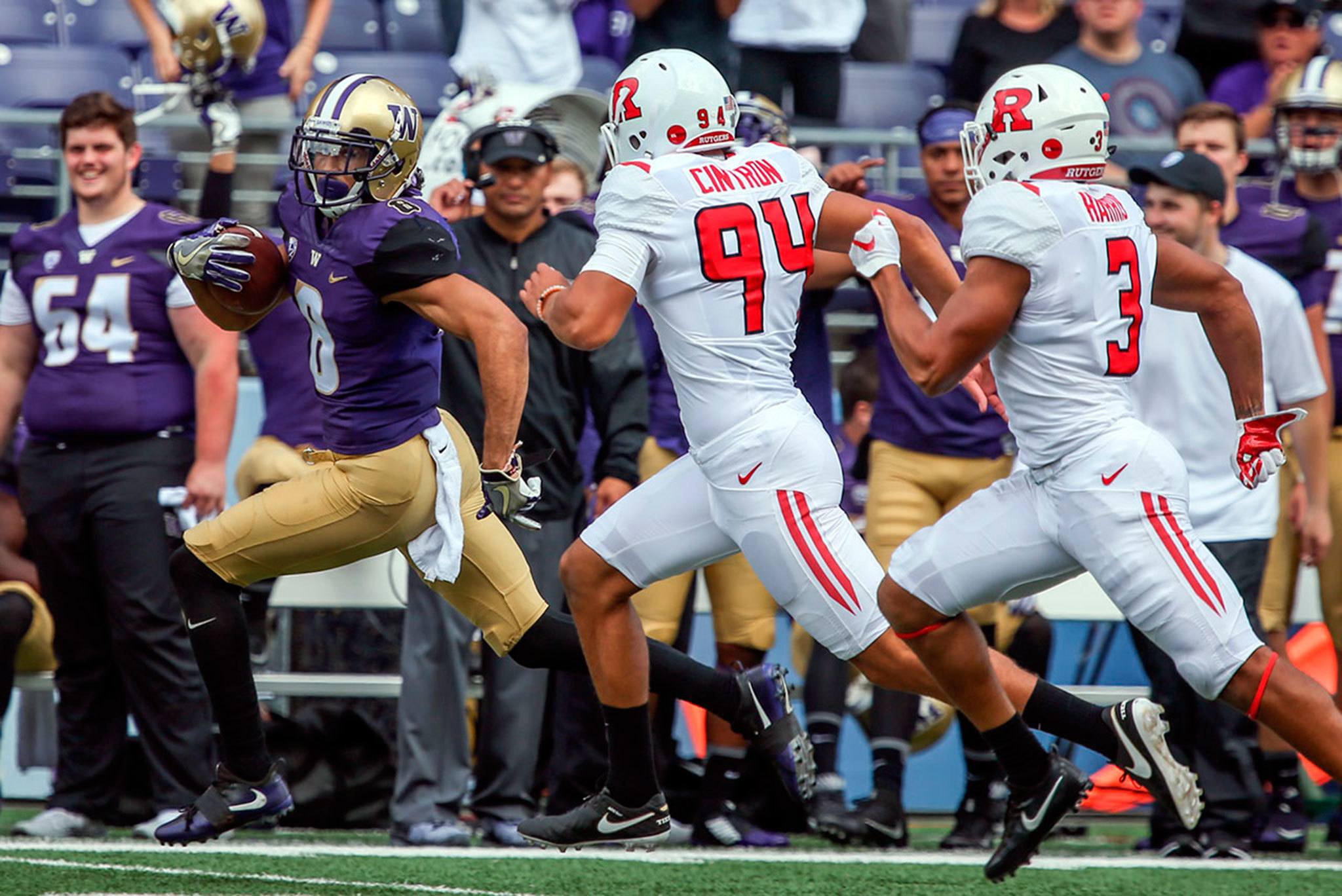 Washington’s Dante Pettis scores on a 68-yard punt return with Rutgers’ Michael Cintron (94) and Jawuan Harris (3) trailing during a game Sept. 3 at Husky Stadium. (Kevin Clark / The Herald)