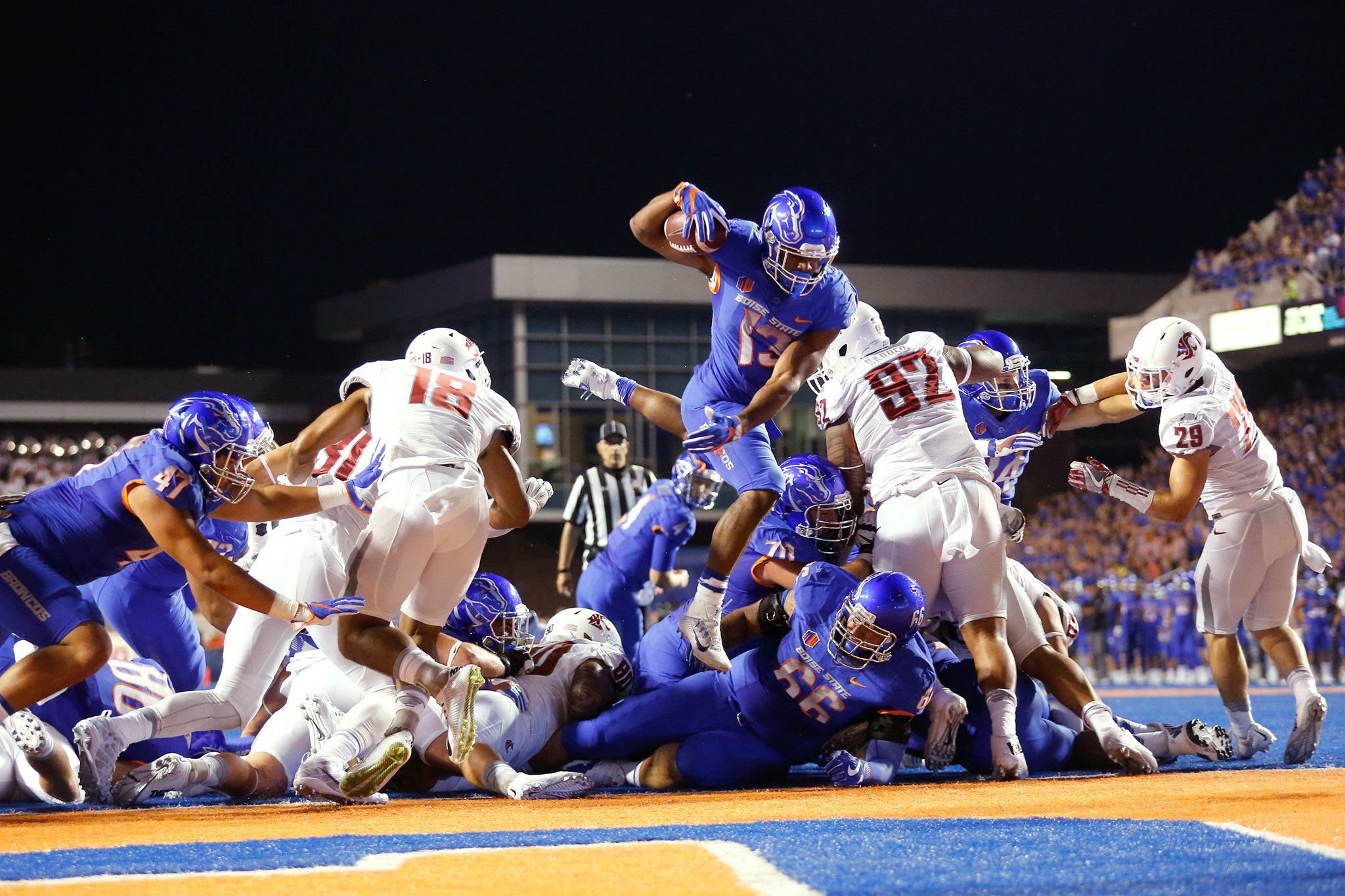 Boise State running back Jeremy McNichols (13) leaps into the end zone for a touchdown during the first half of a game against Washington State on Saturday in Boise, Idaho. The Broncos beat the Cougars 31-28. (AP Photo/Otto Kitsinger)