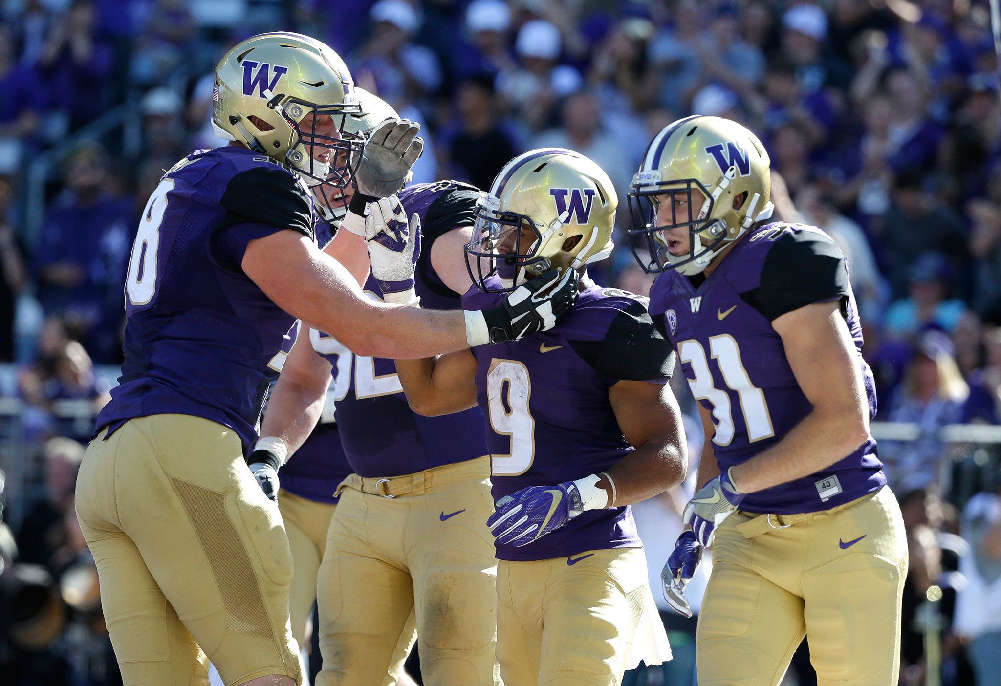 Teammates greet Washington running back Myles Gaskin (9) after Gaskin scored a touchdown against Idaho in the first half of a game Saturday in Seattle. (AP Photo/Ted S. Warren)