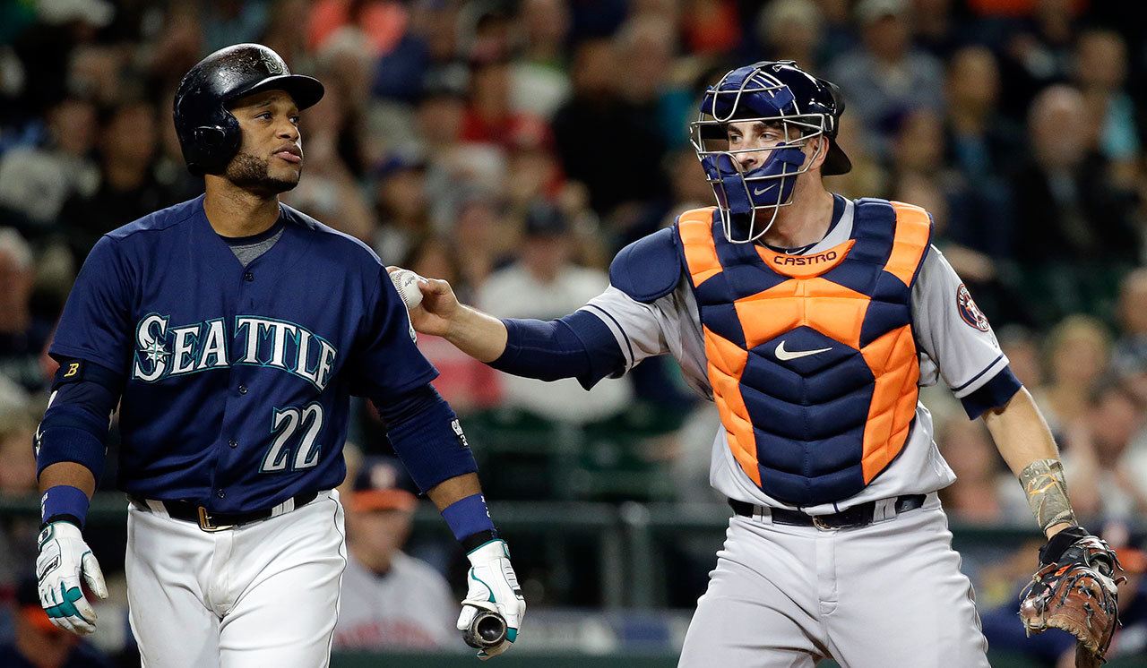 The Mariners’ Robinson Cano (22) is tagged by Astros catcher Evan Gattis after Cano struck out during the eighth inning of a game Saturday in Seattle. (AP Photo/Elaine Thompson)