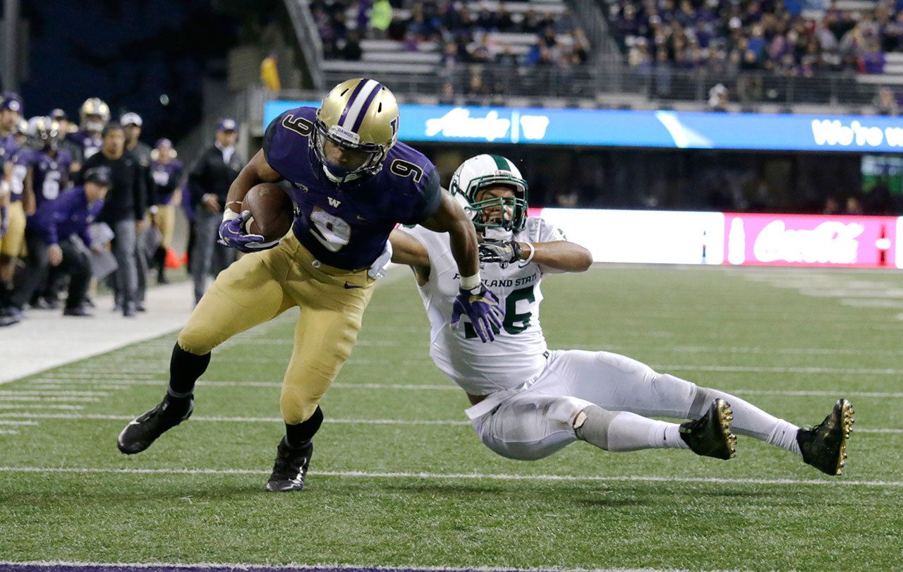 Washington running back Myles Gaskin runs to the end zone for a touchdown evading Portland State defensive end Sam Bodine in the second half of a game Saturday in Seattle. Washington won 41-3. (AP Photo/John Froschauer)