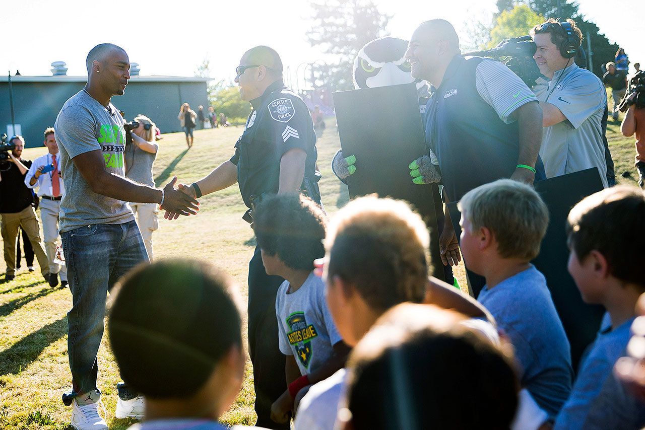Seattle’s Doug Baldwin greets Seattle Police Officer Sergreant Adrian Diaz during a surprise visit to present Diaz with an award on Sept. 13 in Renton. In a press conference Thursday, Baldwin called for the attorneys general of all 50 states to review police policies and training procedures. (Grant Hindsley/seattlepi.com via AP)                                Seahawks wide receiver Doug Baldwin greets Seattle Police Sgt. Adrian Diaz during a surprise visit to present Diaz with the NFL Hispanic Heritage Leadership Award and a grant for $2,000 at practice for his police-sponsored, youth football league in Renton on Tuesday. (Grant Hindsley/seattlepi.com via AP)