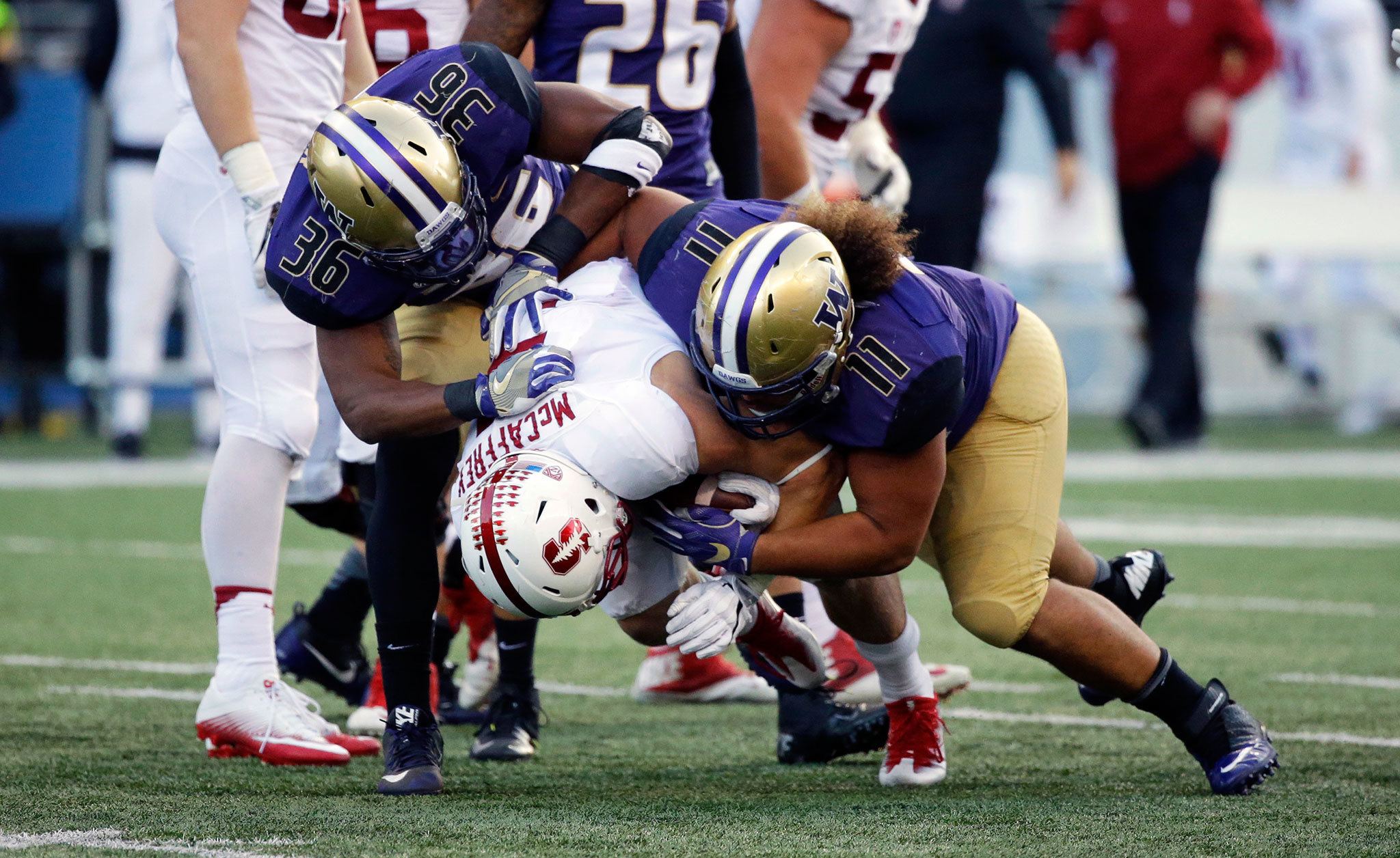 Stanford running back Christian McCaffrey (5) is tackled by Washington linebacker Azeem Victor (36) and defensive lineman Elijah Qualls in the first half of a game Friday in Seattle. (AP Photo/Ted S. Warren)