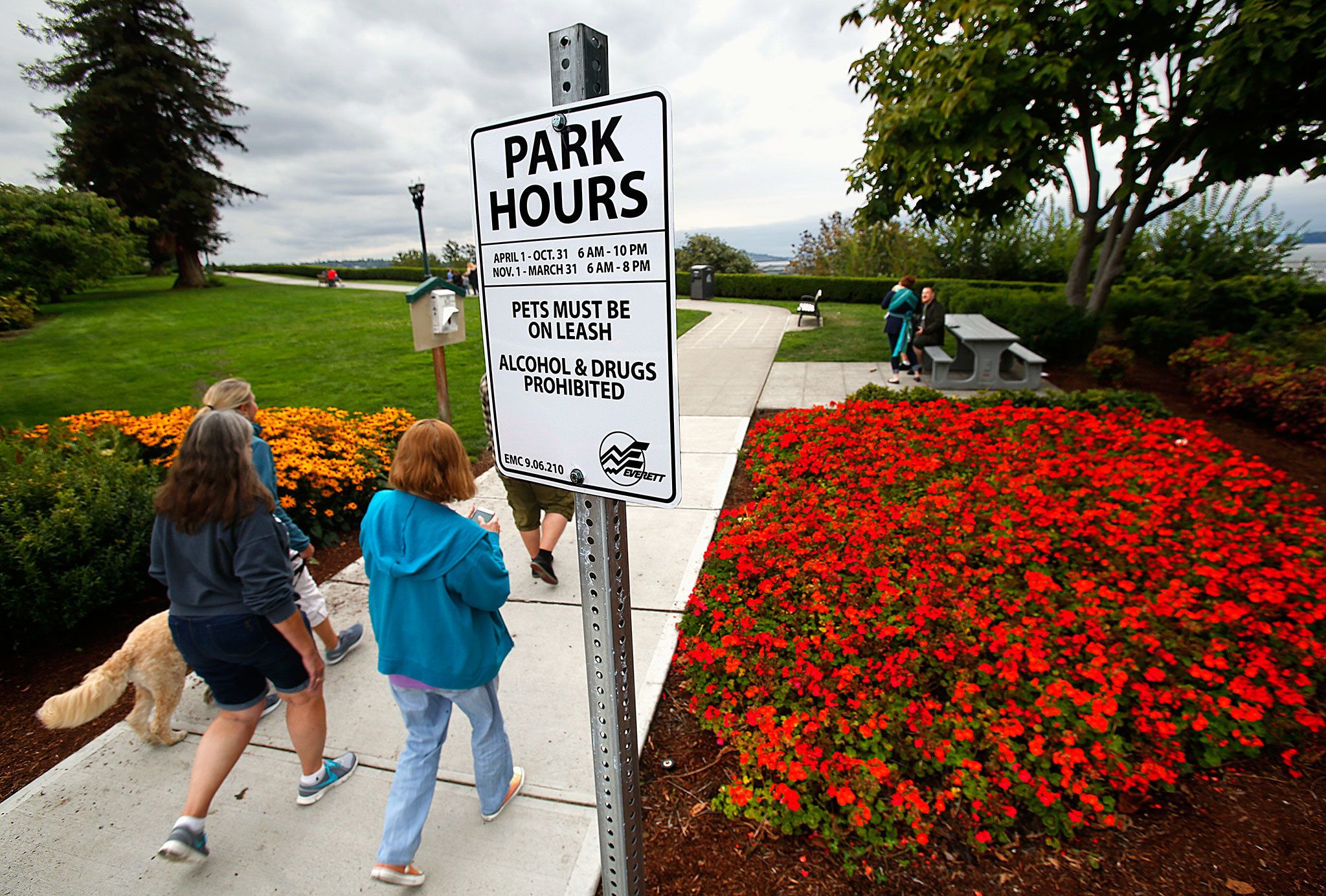Dog walkers at Everett’s Grand Avenue Park were greeted Monday by a new sign spelling out hours: 6 a.m.-10 p.m. April through October and 6 a.m.-8 p.m. November through March. (Dan Bates / The Herald)