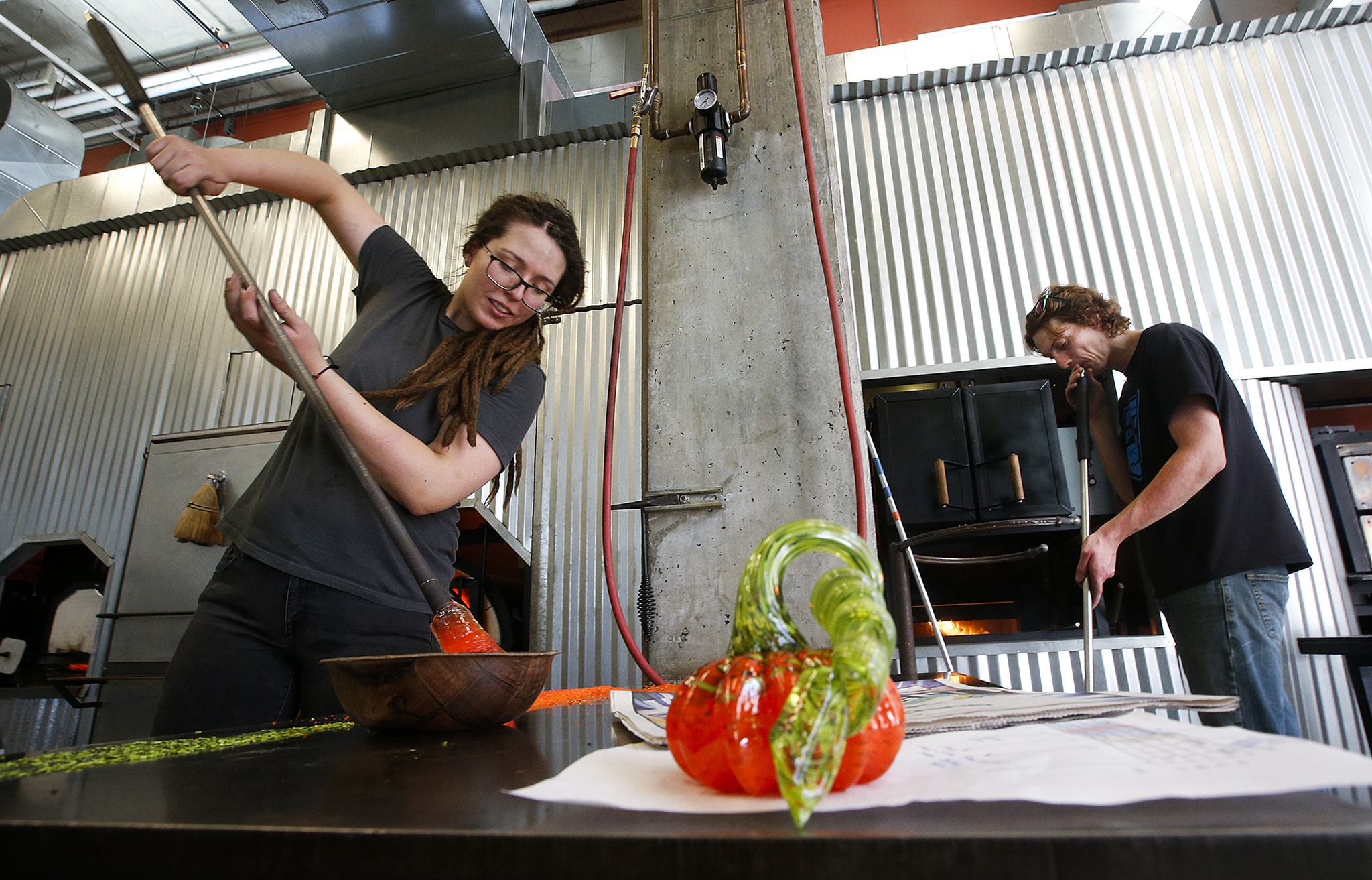 Jo Andersson (left) and Corey Windnagel work to create glass blown pumpkins for Schack-toberfest, the Schack Art Centerճ 6th annual pumpkin festival in downtown Everett from September 15-25, 2016. Andersson estimates over 700 handmade pumpkins will be on display during the exhibit. (Ian Terry / The Herald)