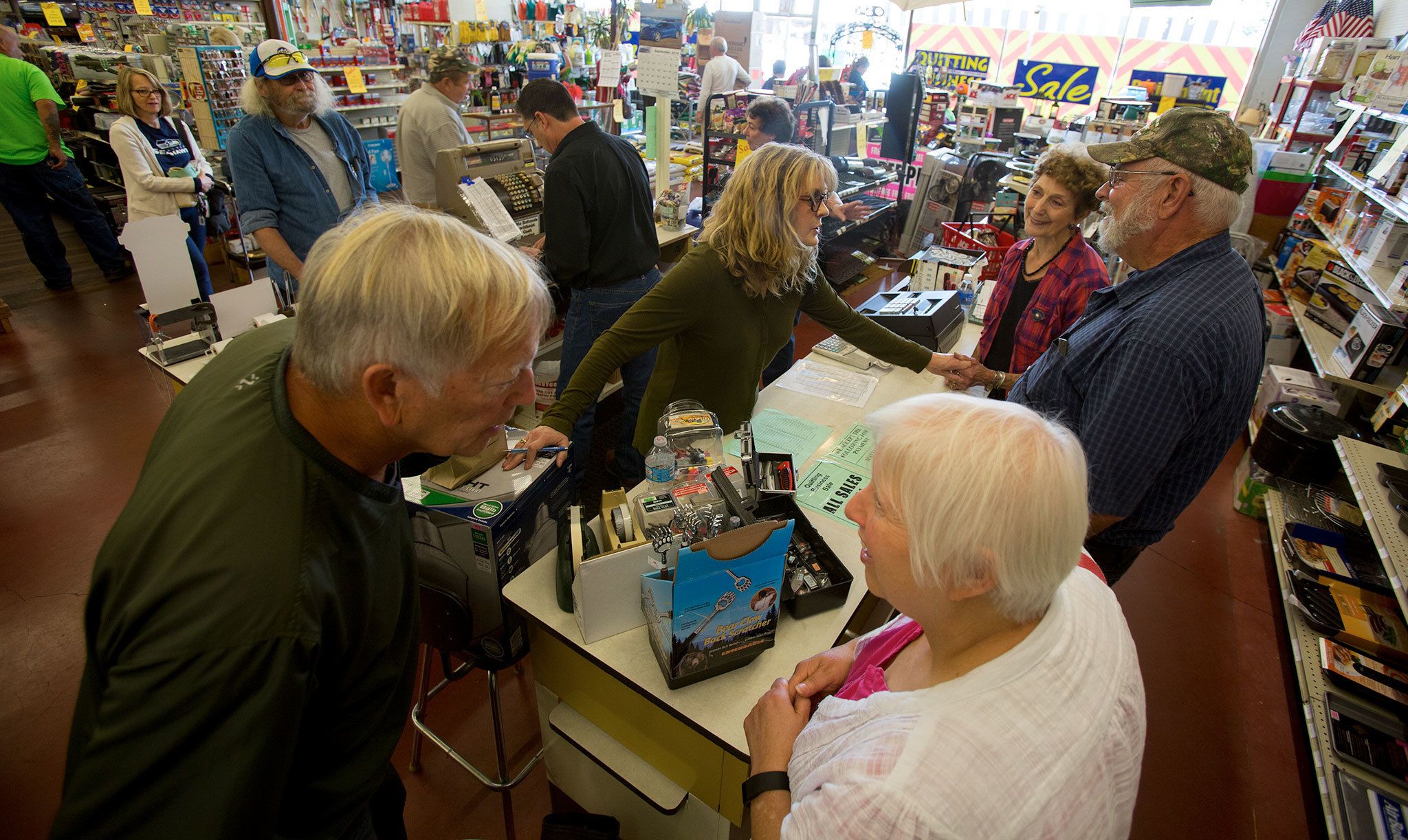 Gail Libbing (center), the third generation of the family to own the store, holds the hand of her mother, Darlene Scott, while talking with long-time customer Al Hendrickson at Carr’s Hardware on Friday in Marysville. Carr’s Hardware is closing after 93 years in business. (Andy Bronson / The Herald)