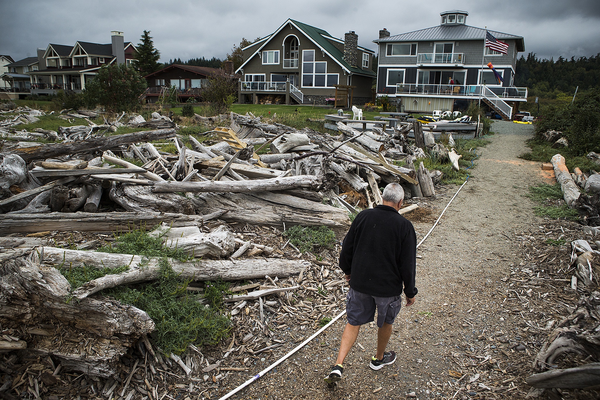 Cliff Marston walks to his house located on Camano Island’s Iverson Road on Sept. 7. Marston said water was about a foot deep on this path during a March storm that flooded some low-lying Island County homes.                                (Ian Terry / The Herald)