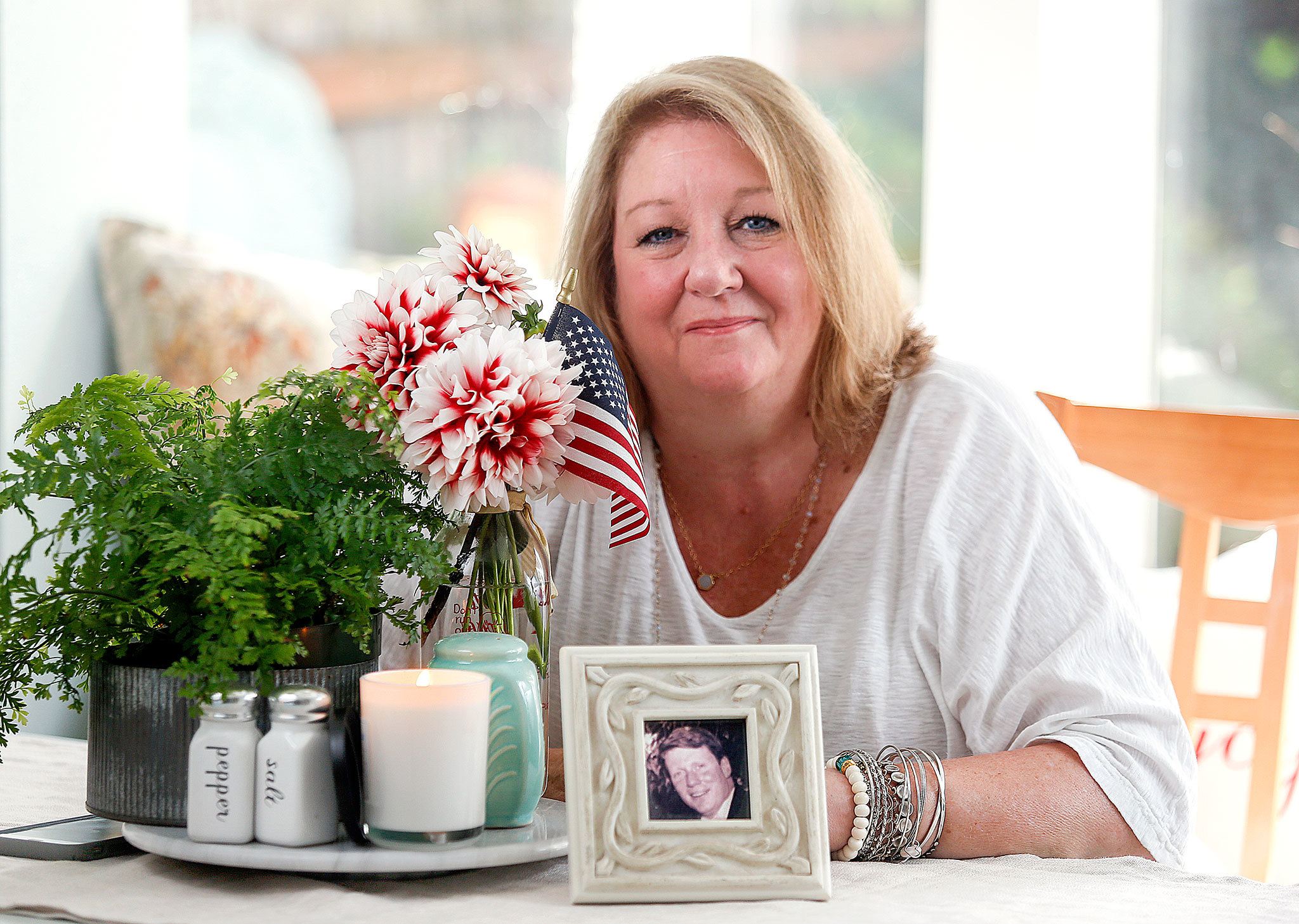 (Dan Bates / The Herald) At Patricia Mackey’s Edmonds home, flags, large and small, have been on display every day since 9/11. A photo of her cousin, Dennis Buckley, who died in the North Tower, sits on the kitchen table. He was 38 and had a wife and three daughters. Mackey, a registered 9/11 family member, doesn’t want people to ever forget. She has been to the site and read the names of victims. (Dan Bates / The Herald)