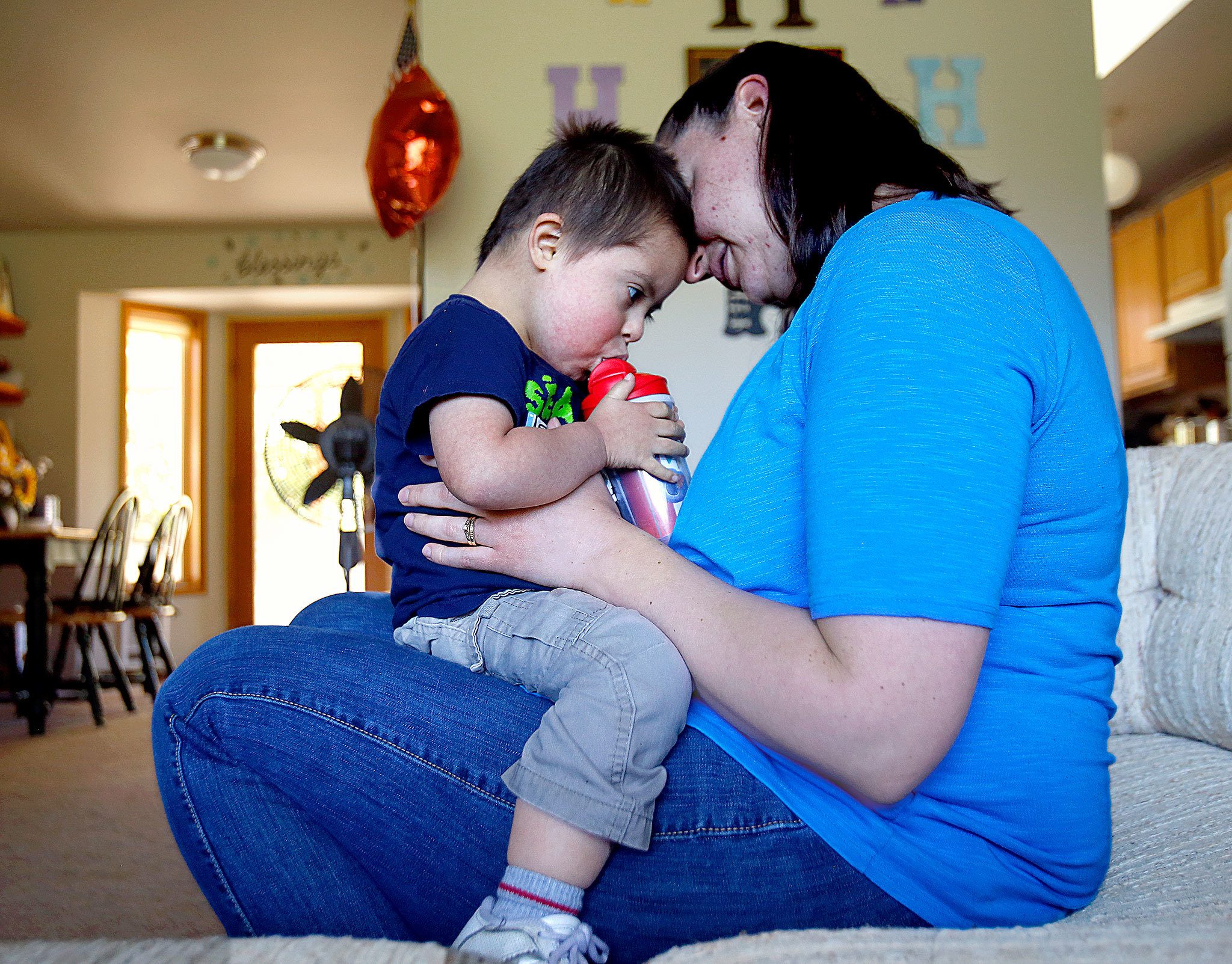 Caitlin Hurley holds her son, Braeden, 3, while the youngster gets a cool drink after playing in the family’s home in Gold Bar on Tuesday. Caitlin and her husband, Caleb, adopted Braeden though the National Down Syndrome Adoption Network. The couple hope to adopt another child with Down syndrome. (Dan Bates / The Herald)