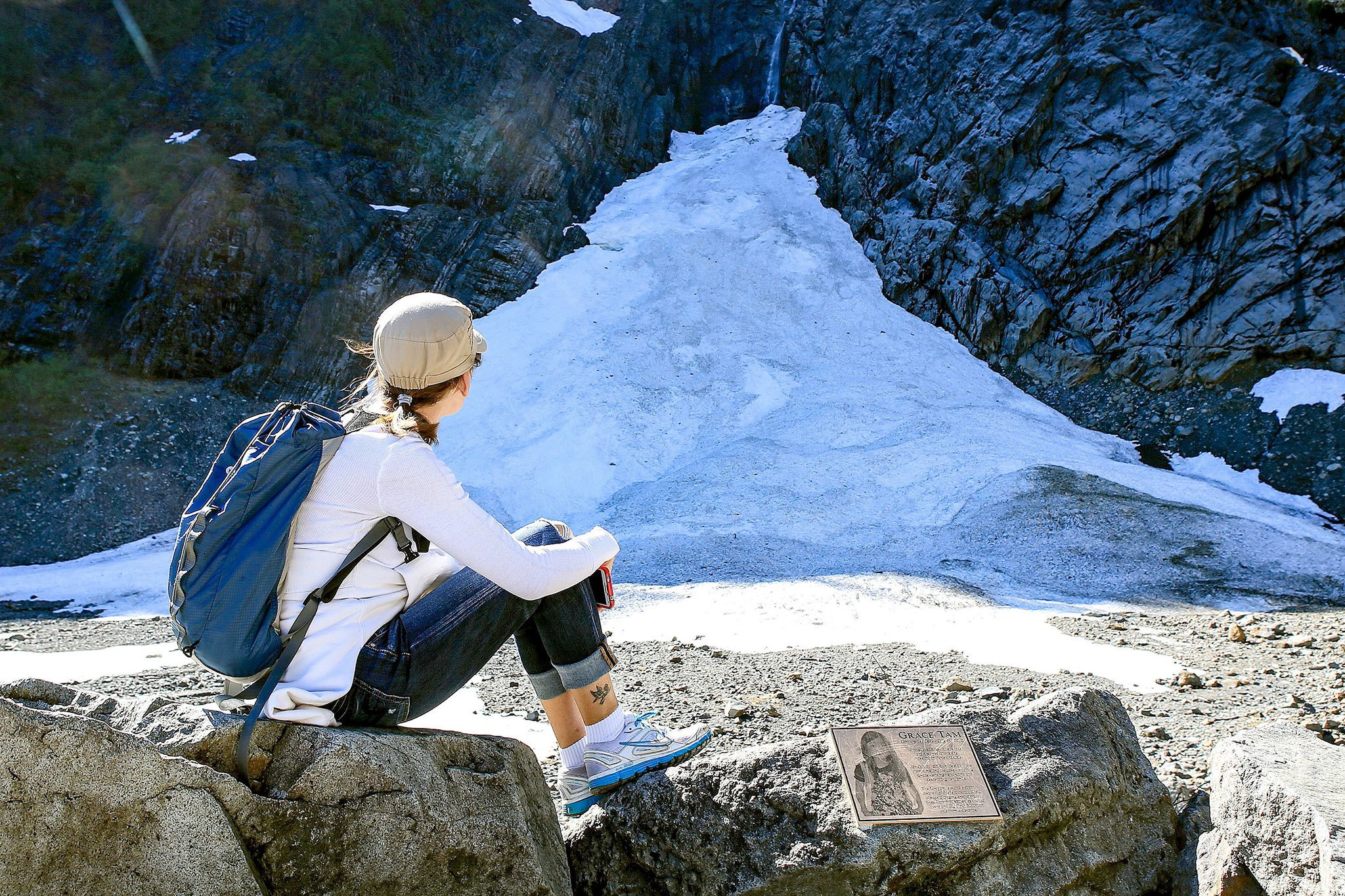 Connie Peterson looks out at the snowpack at the Big Four Ice Caves in Granite Falls on May 1. At right is a memorial plaque to Grace Tam, 11, who died July 31, 2010, after she was struck by a piece of ice while visiting the site with her family. (Kevin Clark / The Daily Herald, file)