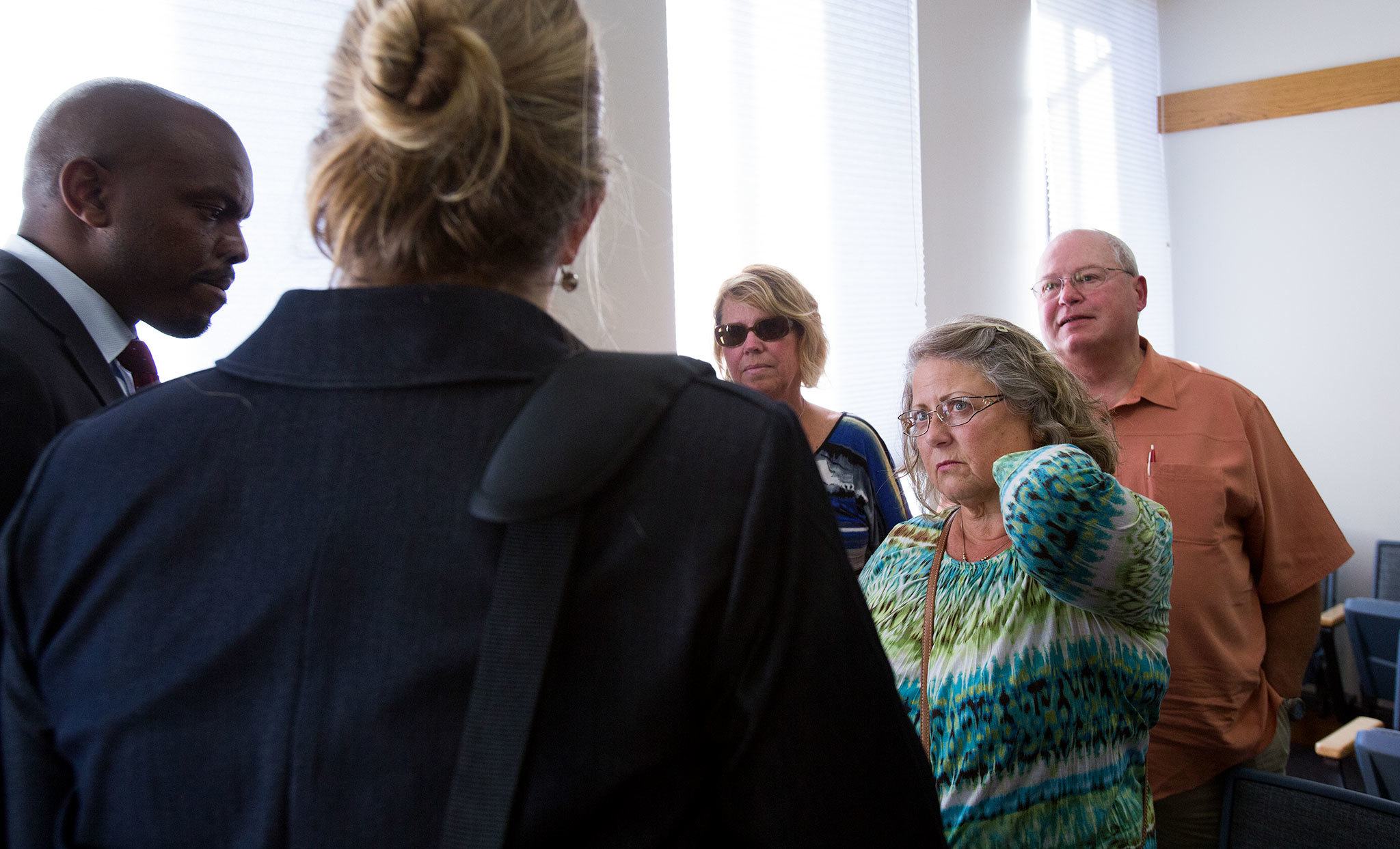 Denise Webber (second from right), mother of Rachel Burkheimer, listens to Snohomish County deputy prosecutors Edirin Okoloko and Julie Mohr as they explain Judge Linda Krese’s decision to rule later on a possible mistrial during proceedings at Snohomish County Courthouse on Wednesday in Everett. (Andy Bronson / The Herald)