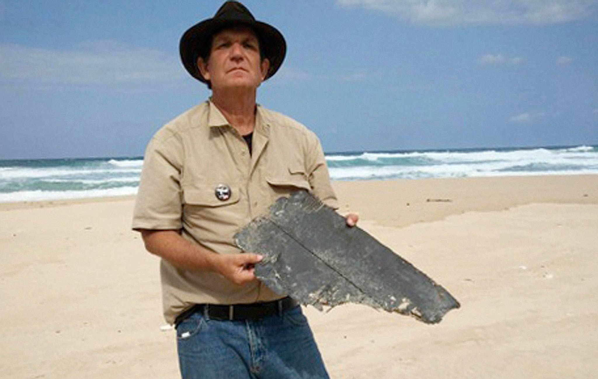 Blaine Gibson holds a piece of 777 aircraft debris on a beach in Madagascar on Sept. 16. (Associated Press)