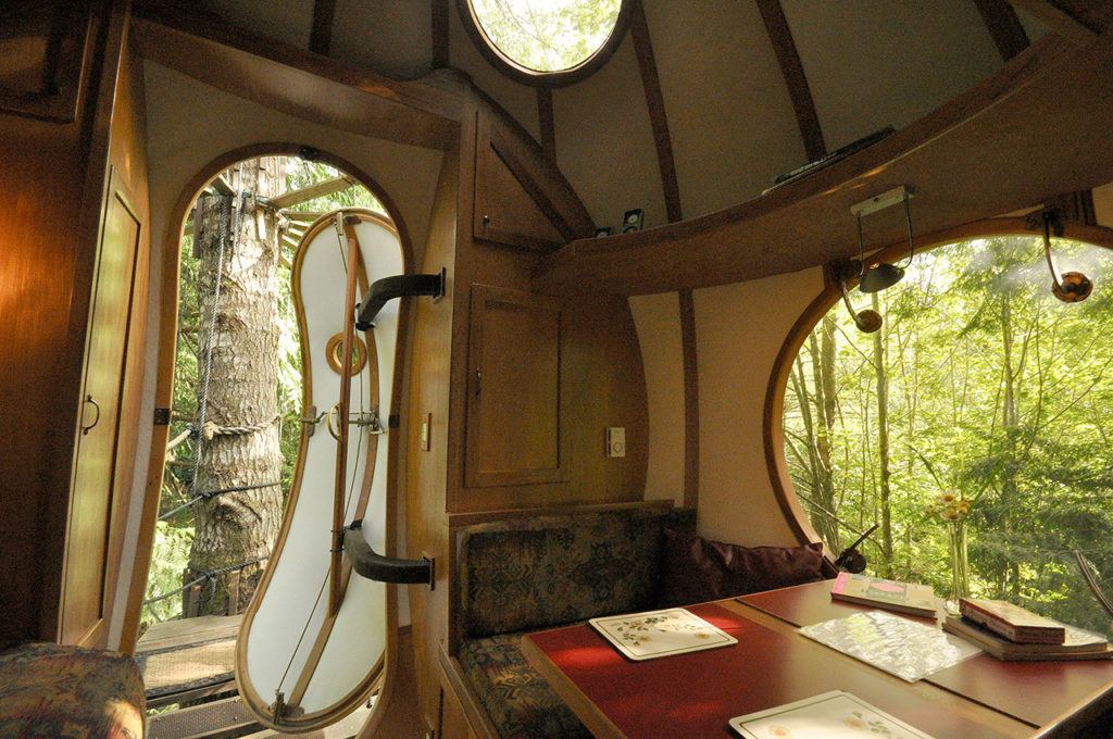 In Vancouver Island’s rain forest, visitors can book sphere rooms in a treehouse hotel. Shown is the Eryn sphere’s interior with views of the forest through the doorway, skylight, and table-side window. (Photo by Adam Clarke)
