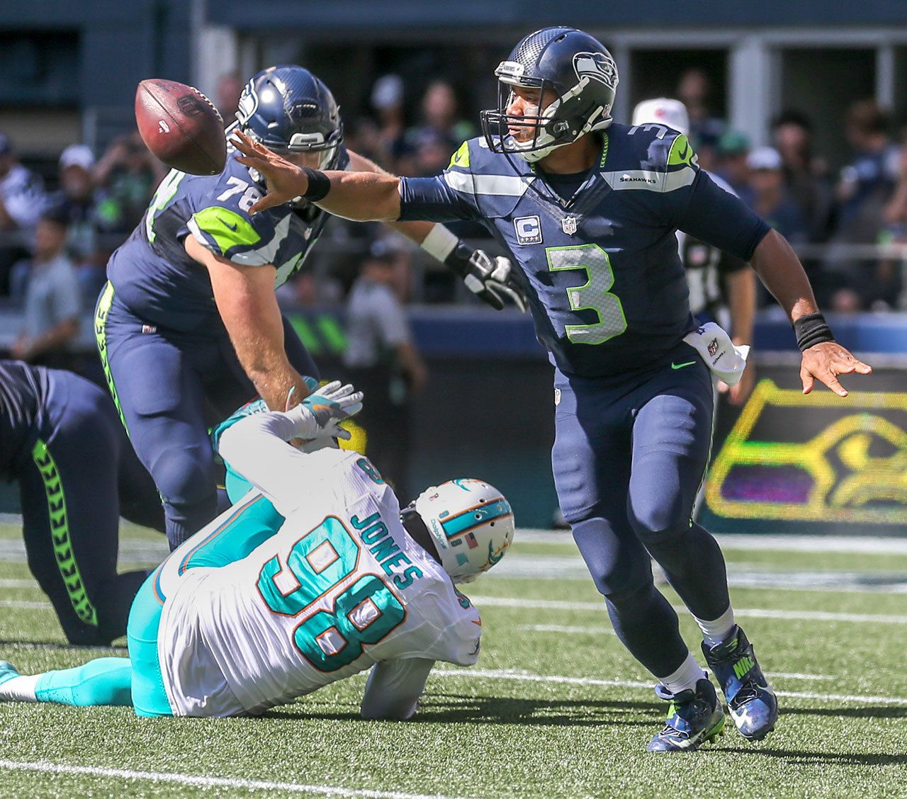 Seahawks quarterback Russell Wilson attempts a shuffle pass against the Dolphins at CenturyLink Field in Seattle on Sunday. The Seahawks defeated the Dolphins 12-10. (Kevin Clark / The Herald)
