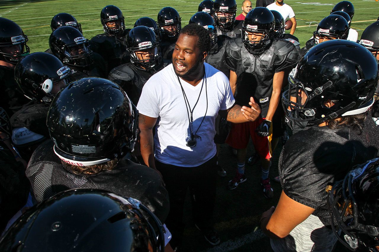 Lynnwood head coach Keauntea Bankhead (center) talks to his team during practice Wednesday afternoon at Lynnwood High School in Bothell. (Kevin Clark / The Herald)