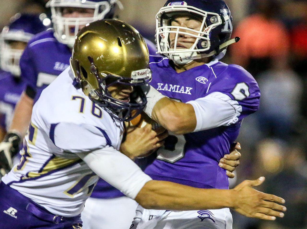 Oak Harbor’s Ozell Jackson sacks Kamiak’s Matt Merk during a game Thursday night at Goddard Stadium in Everett. (Kevin Clark / The Herald)