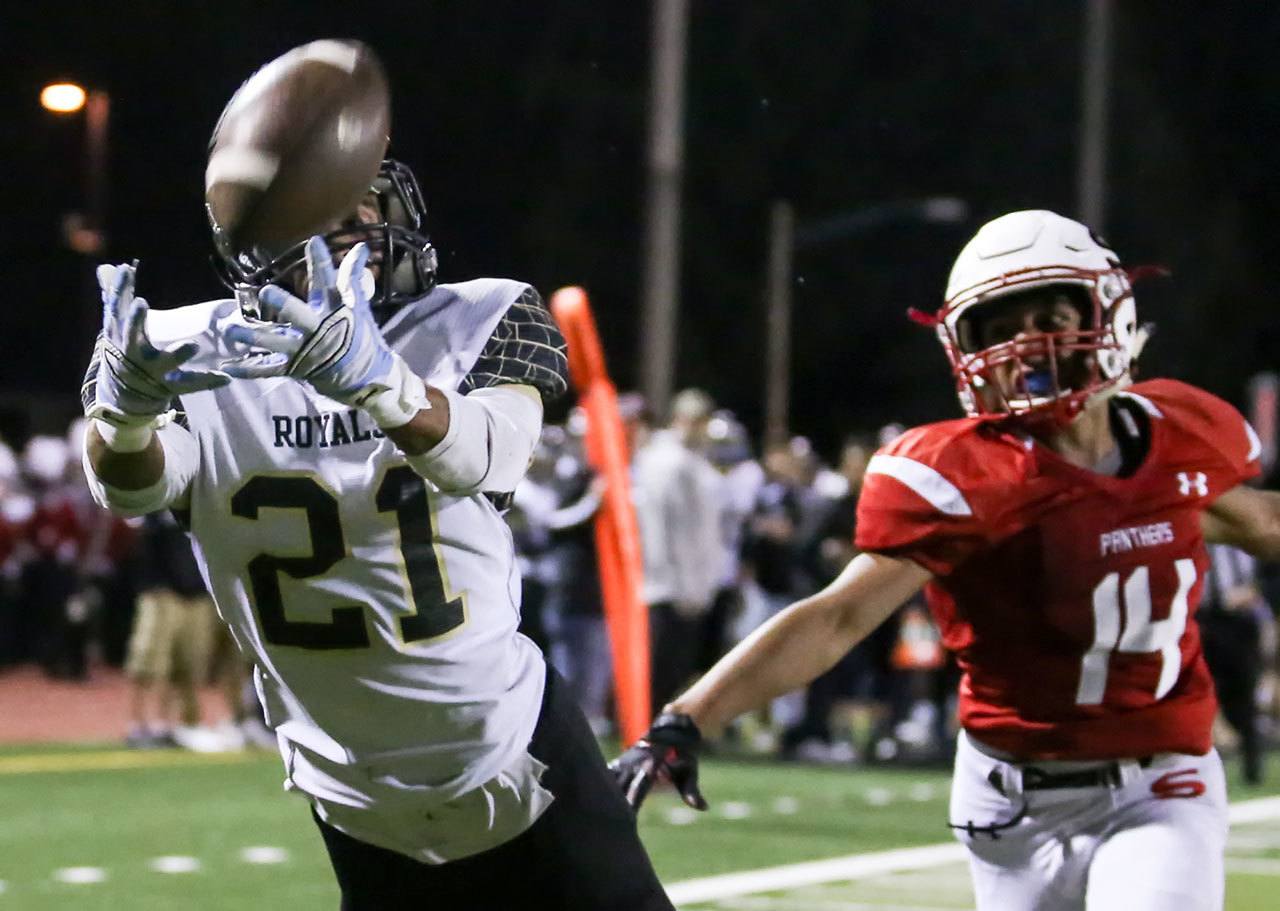 Lynnwood’s Ryley Johnson reaches out for a reception with Snohomish’s Kevin Lopez trailing during a game Friday night at Veterans Memorial Stadium. (Kevin Clark / The Herald)