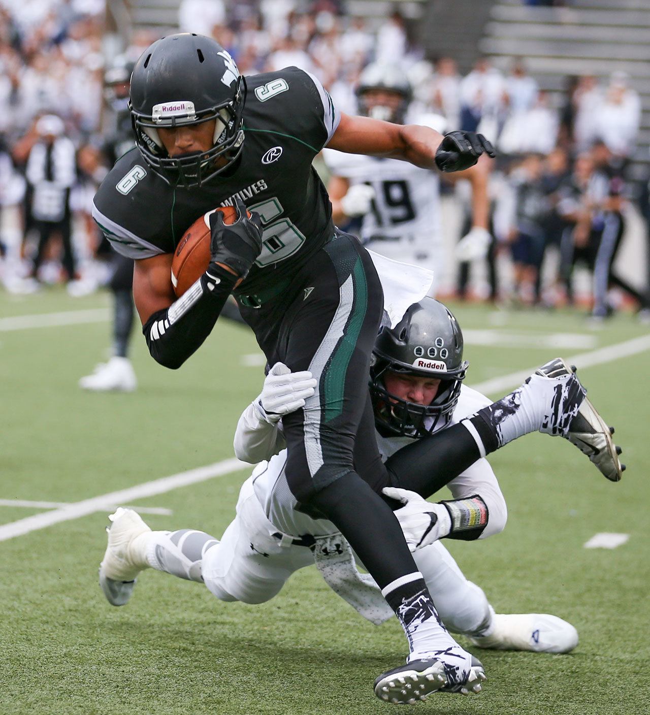 Glacier Peak’s Colton Bunt attempts to tackle Jackson’s Daniel Arias during a game Friday night at Everett Memorial Stadium. (Kevin Clark / The Herald)