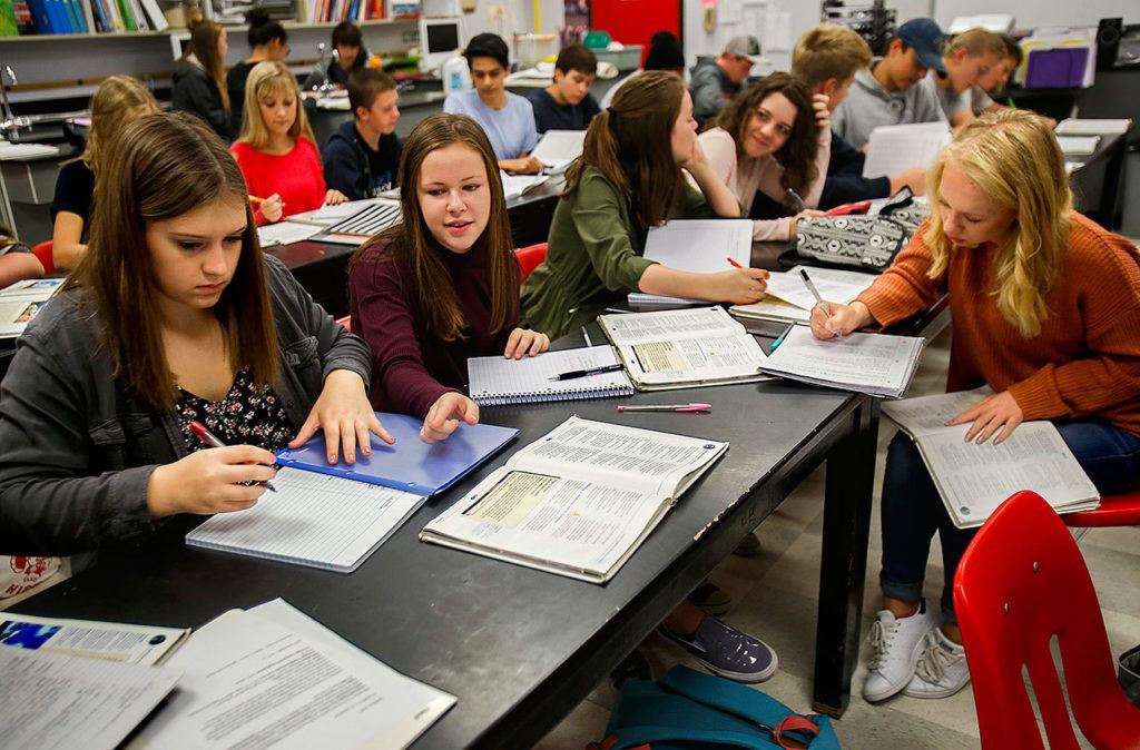 Students in Susan Britain’s 9th-grade science class have no room to spare as they work on chemistry assignments Thursday at Stanwood High School. Under the crowded tables are their backpacks holding their books and supplies. There is almost no storage remaining for such basic needs. (Dan Bates / The Herald)
