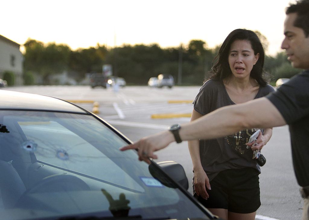 Alan Wakim shows his wife, Jennifer Molleda, where two bullets entered his windshield and went past his face during a shooting along Wesleyan at Law Street in Houston that left multiple people injured and the alleged shooter dead, Monday morning in Houston. (Mark Mulligan/Houston Chronicle via AP)
