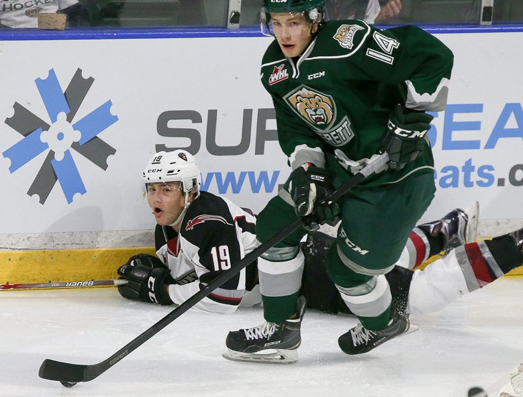 Everett’s Riley Sutter controls the puck with the Giants’ Dawson Holt trailing during a game Saturday at Xfinity Arena in Everett. (Kevin Clark / The Herald)
