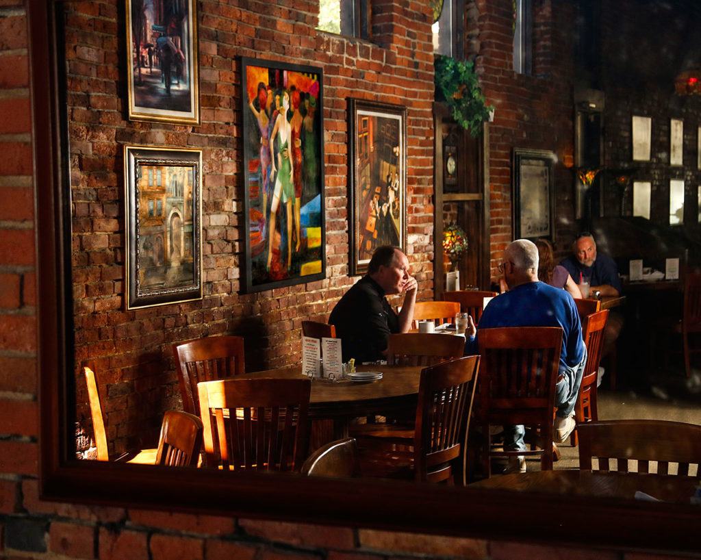 A reflection in a large mirror near the back of the Vintage Cafe captures some of the relaxed, colorful setting that attracts regular customers. (Dan Bates / The Herald)
