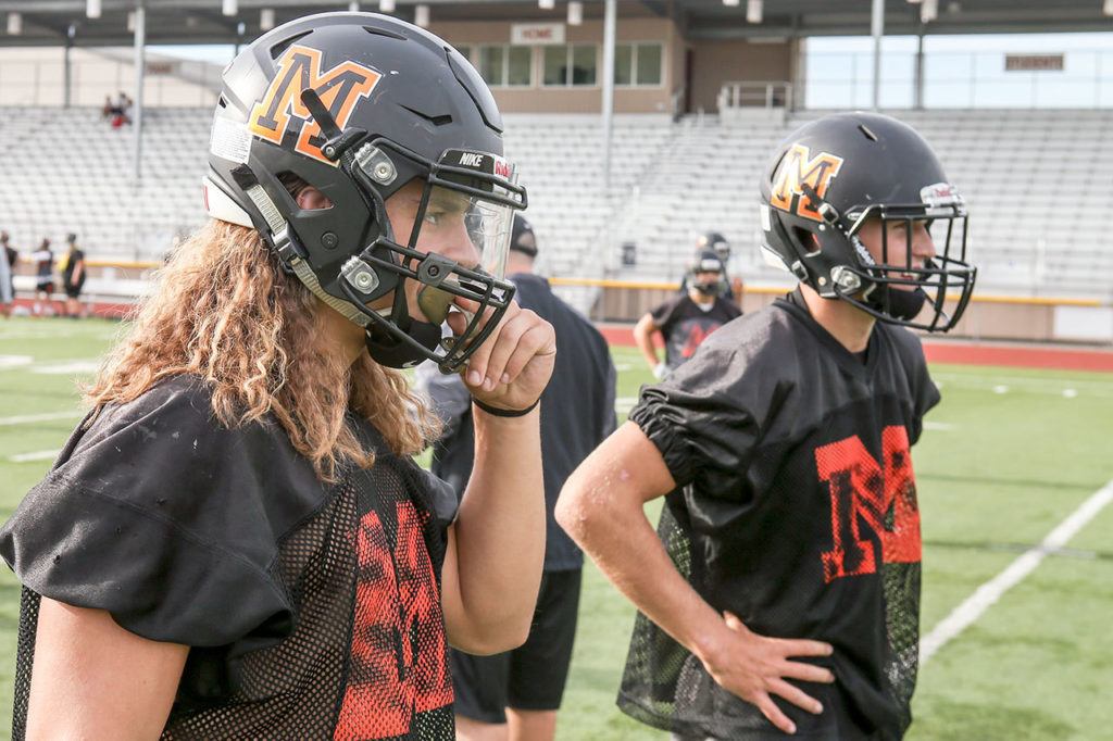Monroe’s JJ Jerome (left) and Zach Zimmerman look to the coaches for a play during practice Thursday afternoon at Monroe High School. (Kevin Clark / The Herald)
