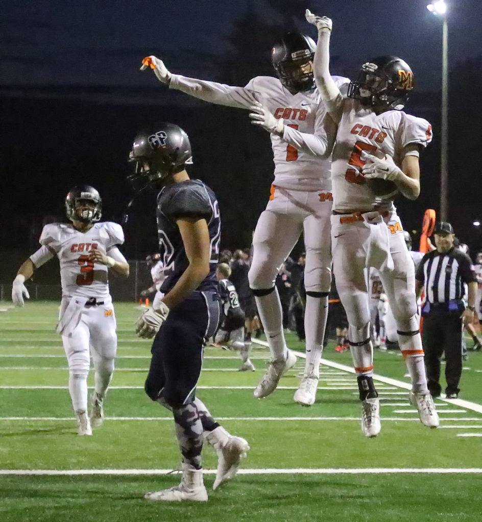 Monroe’s Jason Cyr celebrates with teammate Blake Bingham after a touchdown with Glacier Peak’s Heston Pettis walking away Friday night at Veterans Memorial Stadium in Snohomish. (Kevin Clark / The Herald)

