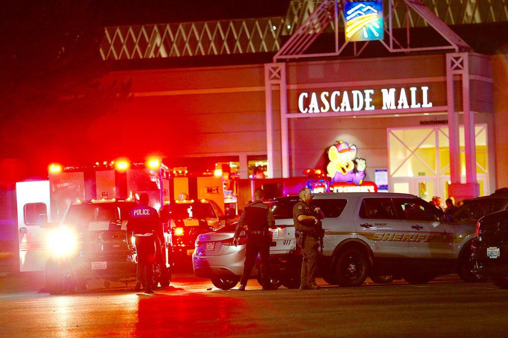Law enforcement officers work at the crime scene outside of Cascade Mall in Burlington, where three people were fatally shot on Friday. (Dean Rutz/The Seattle Times via AP)
