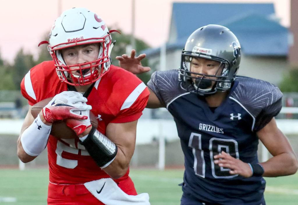 Snohomish’s Josh Johnston runs for additional yards after a reception with Glacier Peak’s Sean Bad trailing Friday night at Veterans Memorial Stadium in Snohomish. (Kevin Clark / The Herald)
