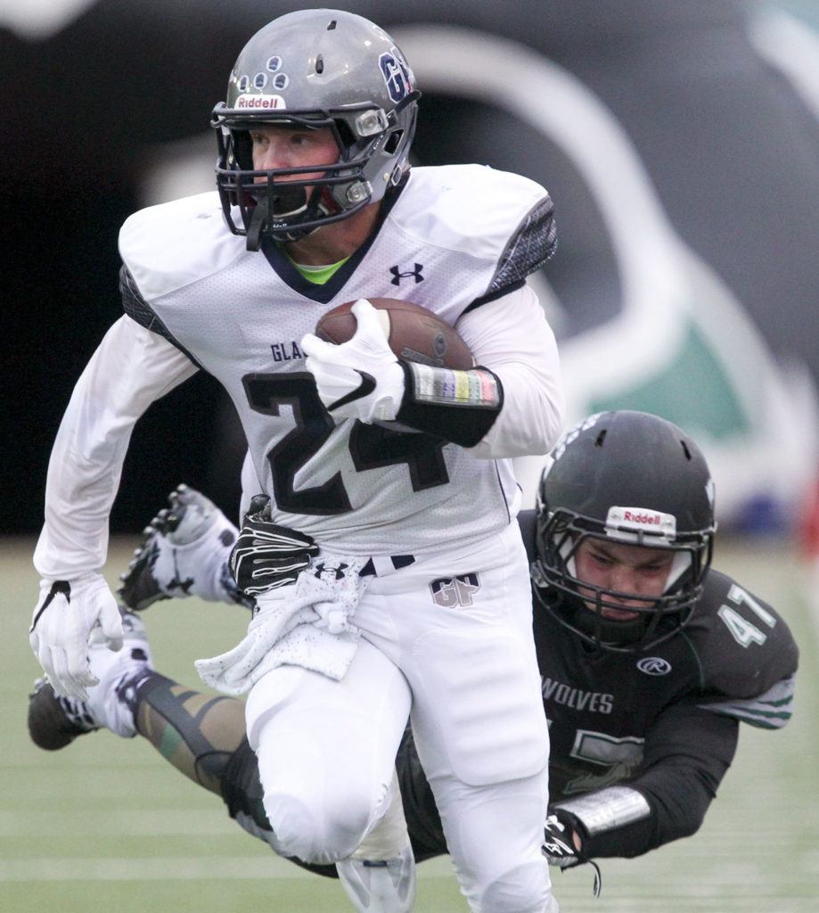 Glacier Peak’s Colton Bunt struggles for more yards with Jackson’s Clint Wagner attempting a tackle during a game Friday night at Everett Memorial Stadium. (Kevin Clark / The Herald)
