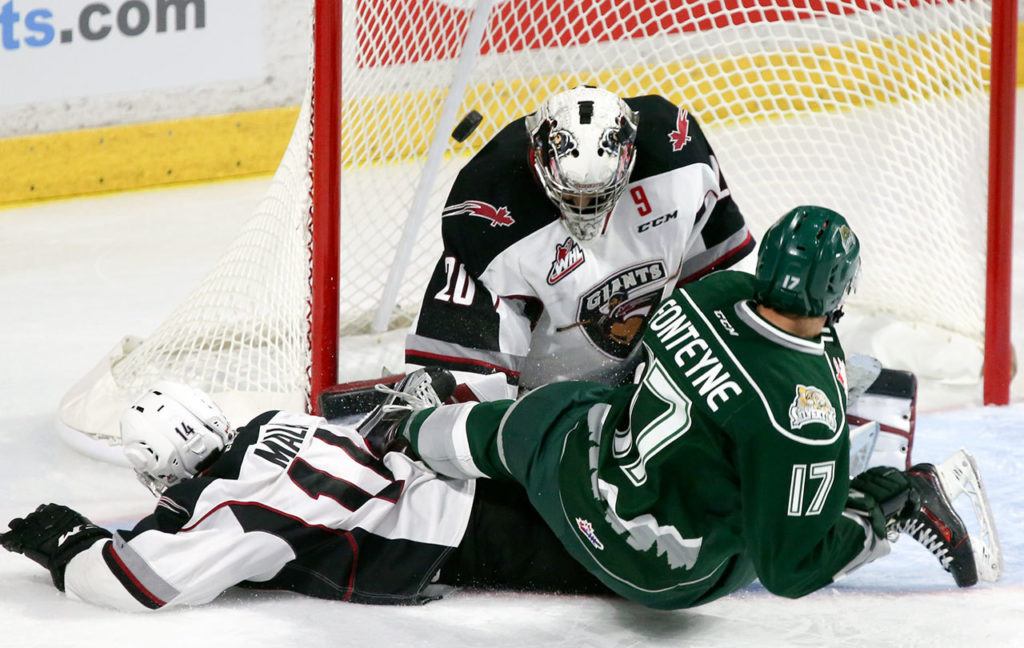 Everett’s Matt Fonteyne slides into Giants goalie Gage Ramsay with the Giants’ James Malm looking on during a game Saturday at Xfinity Arena in Everett. (Kevin Clark / The Herald)
